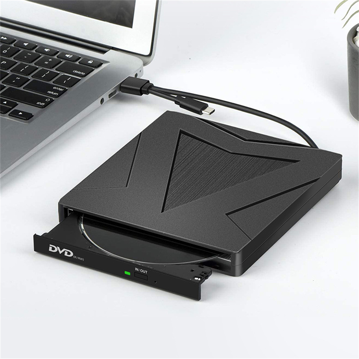 Schwarzes externes DVD-Laufwerk, über USB mit einem Laptop verbunden, zeigt ein offenes Laufwerk.