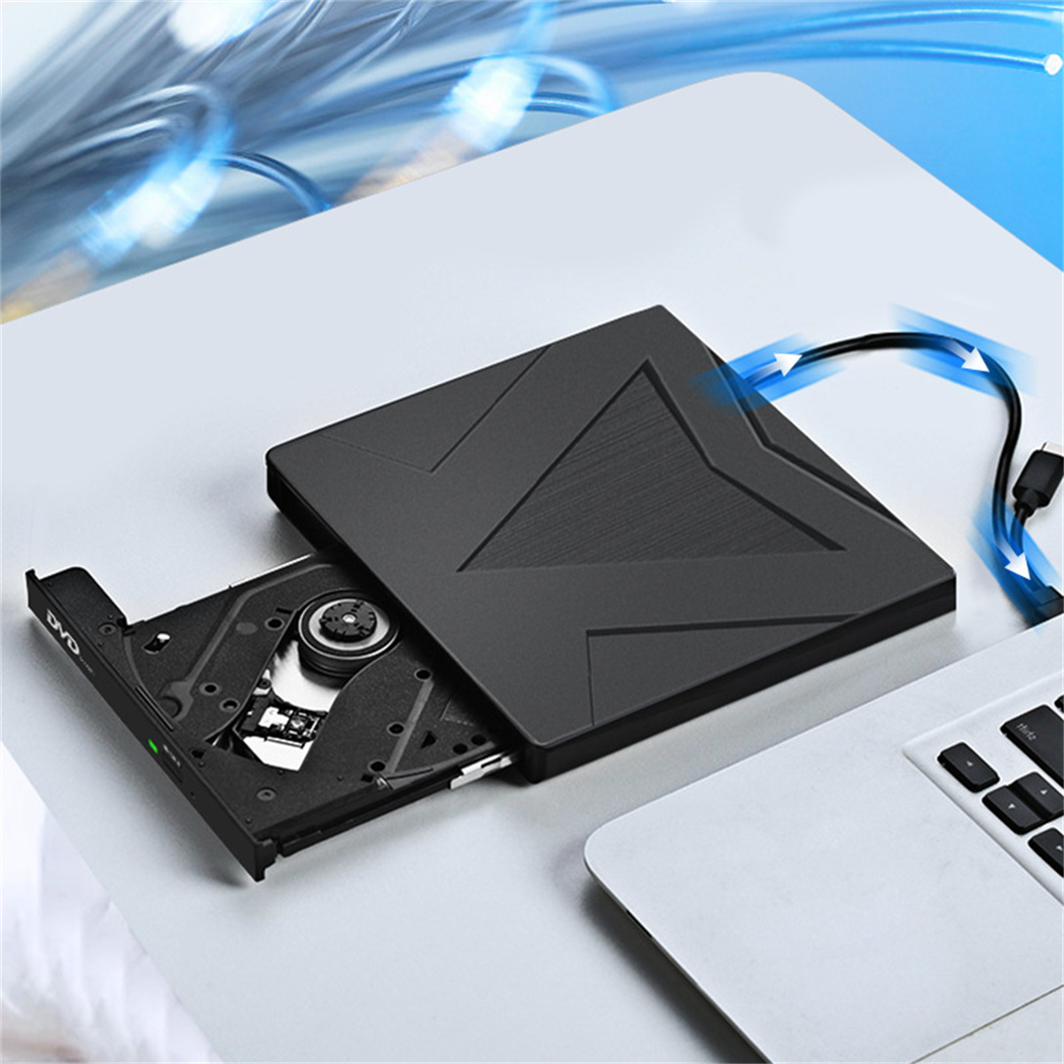 Schwarzes externes DVD-Laufwerk geöffnet und mit einem Laptop verbunden. Es befindet sich auf einem weißen Schreibtisch. Blauer Lichteffekt.