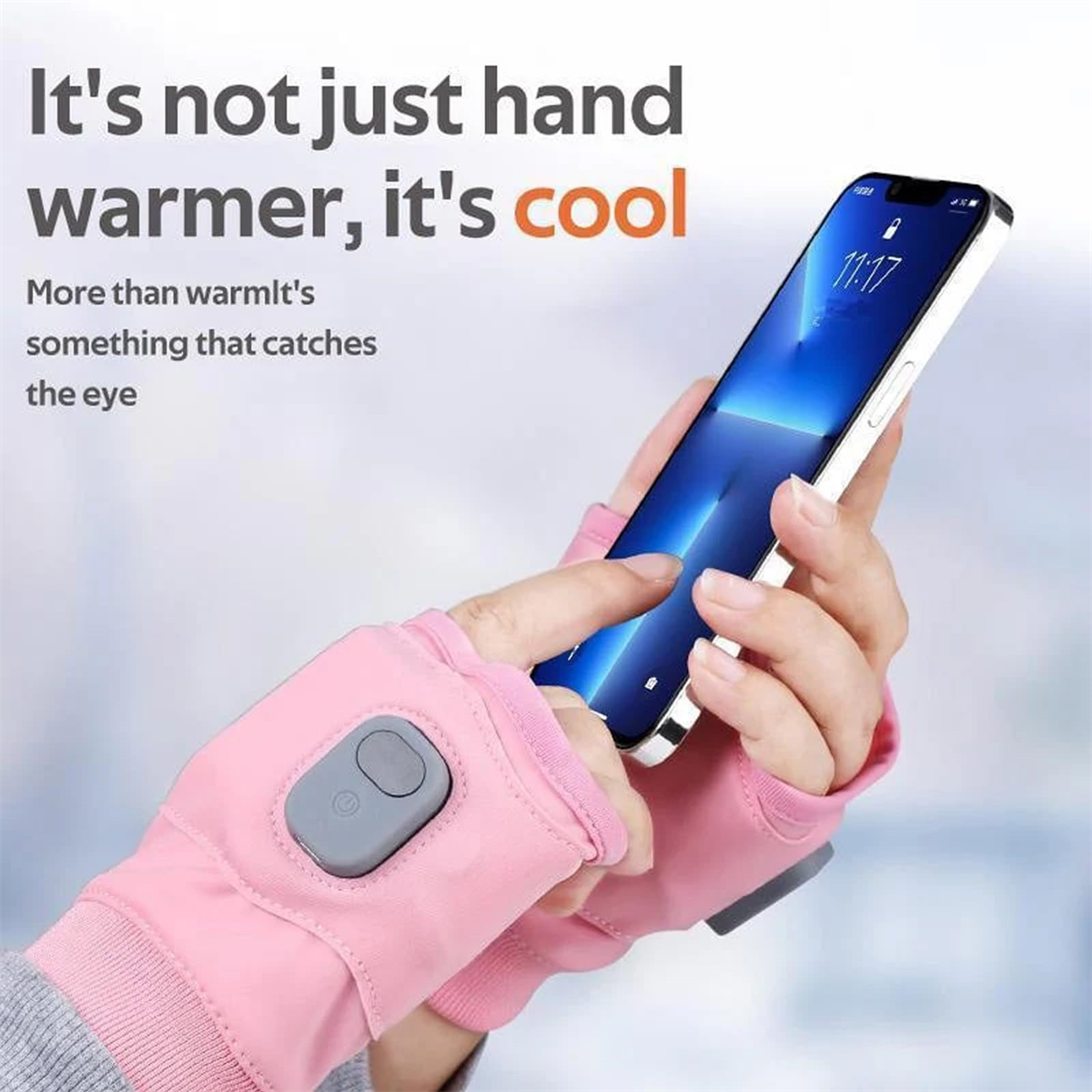 Beheizbare rosa Handschuhe mit einem Bedienknopf, Person hält Telefon.