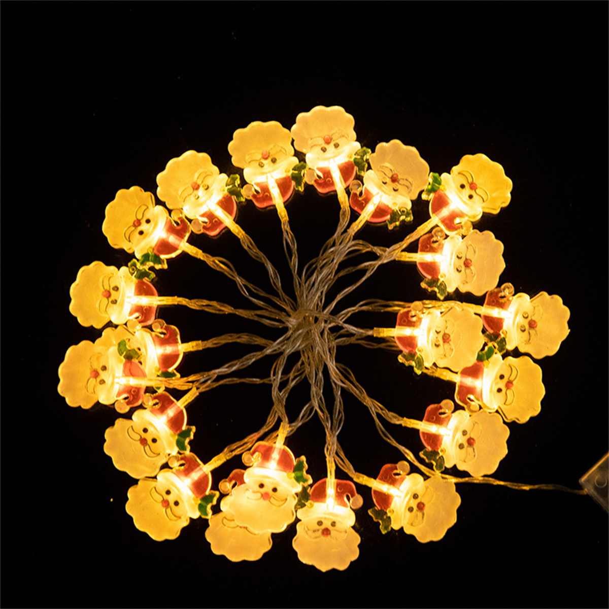 Eine Lichterkette mit Weihnachtsmannfiguren, die auf dunklem Hintergrund leuchtet.