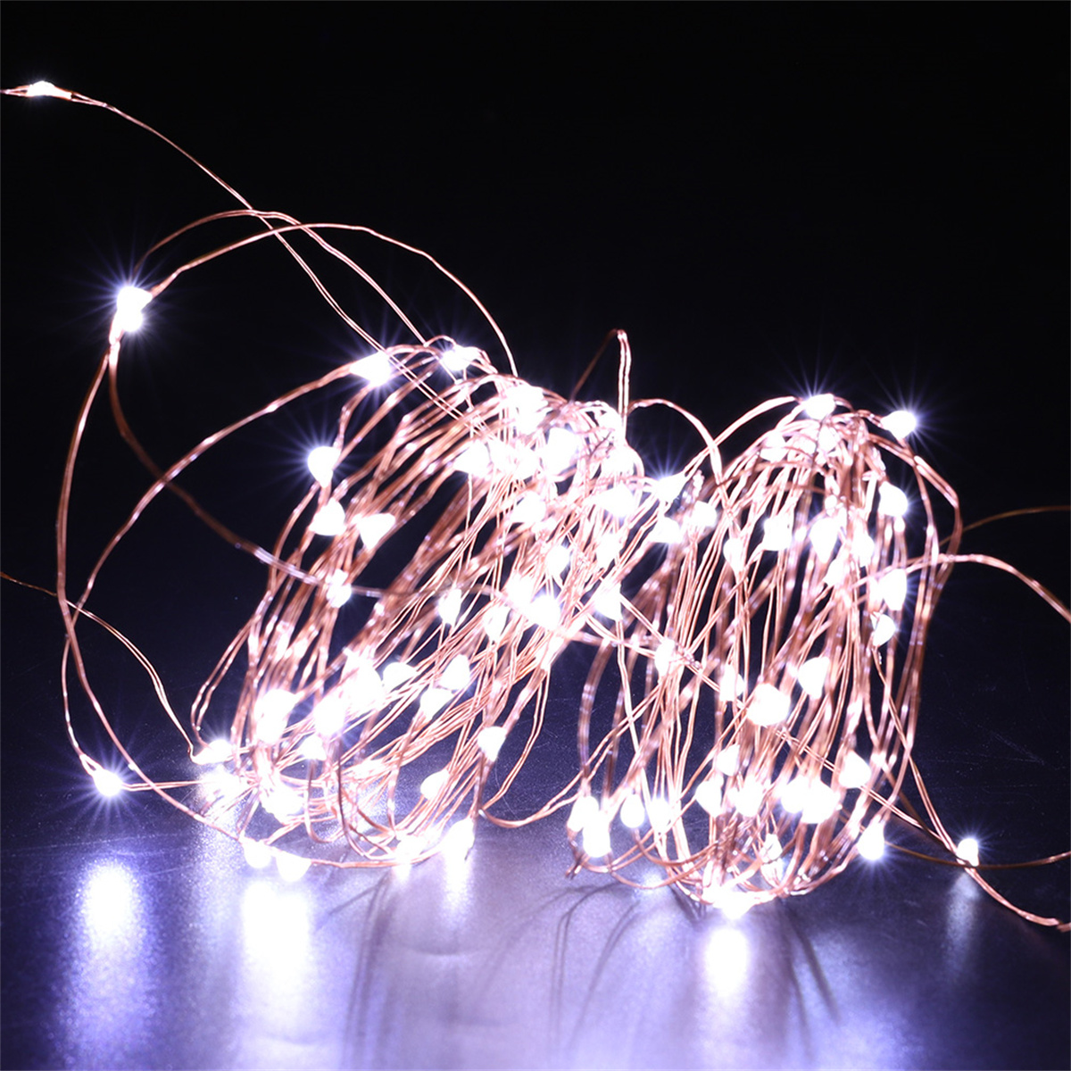 Kupferdraht-Lichterketten mit kleinen weißen LEDs. Sie sind in einem verworrenen, leuchtenden Muster angeordnet.