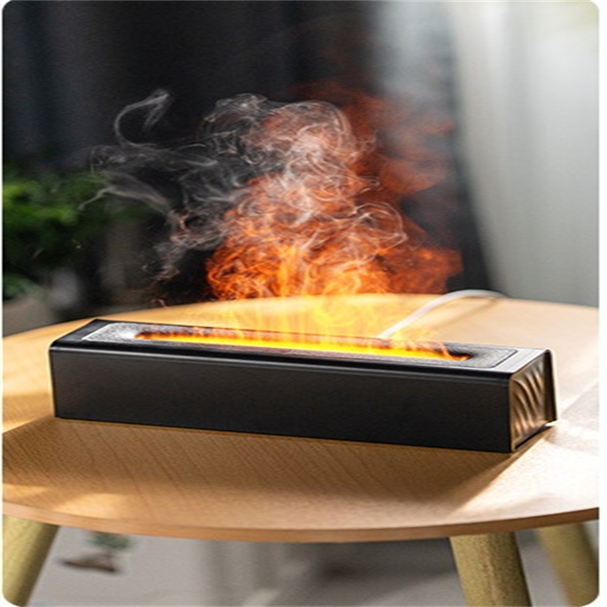 Ein schwarzer Aromatherapie-Diffusor mit orangefarbenem Flammeneffekt, auf einem Holztisch platziert.