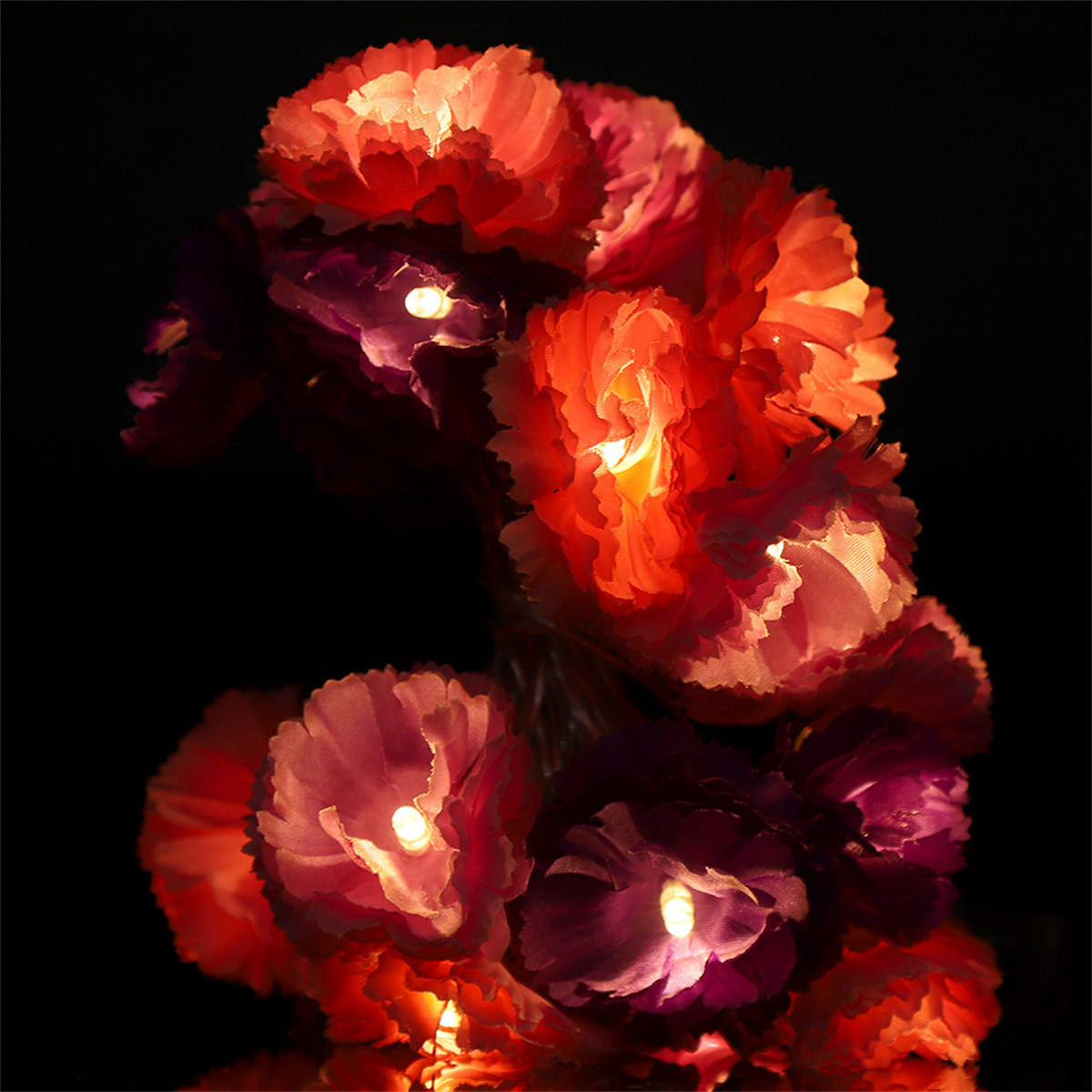 Blumenarrangement mit leuchtenden Lichtern, zeigt verschiedene farbige Blumen.