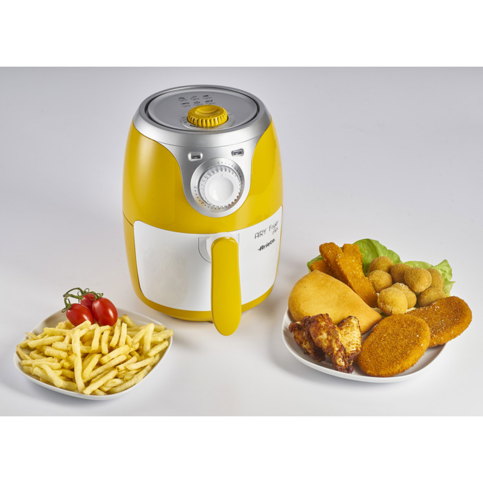 Freidora de aire amarilla con muestras de comida en platos. Incluye patatas fritas y fritos variados.
