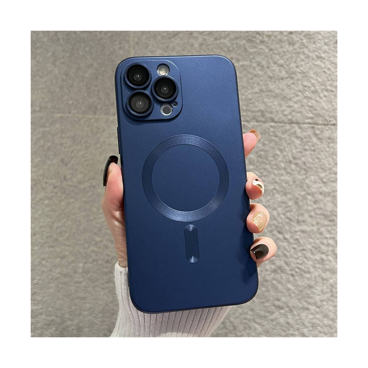 Una mano che tiene un telefono blu scuro con un rigonfiamento della fotocamera.