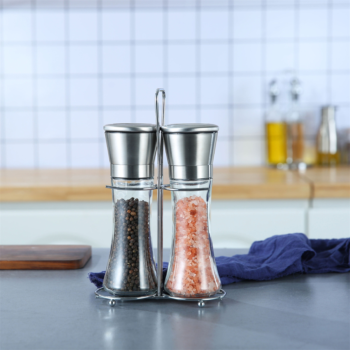 Salz- und Pfefferstreuer auf einem Metallständer. Einer hat schwarzen Pfeffer und der andere rosa Salz.