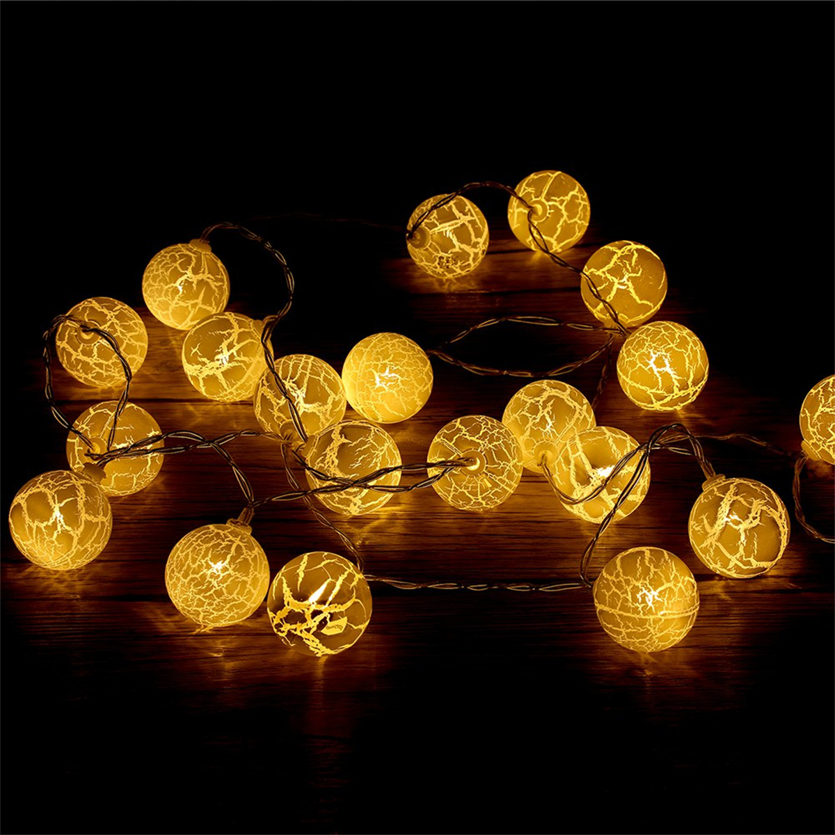 Lichterkette mit leuchtenden gelben Glühbirnen auf dunklem Holz. Dunkler Hintergrund, der eine warme Atmosphäre schafft.