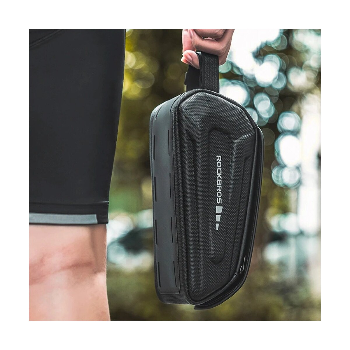 Eine schwarze Fahrradtasche, die von einer Hand gehalten wird, zeigt eine rechteckige Form mit Logo.