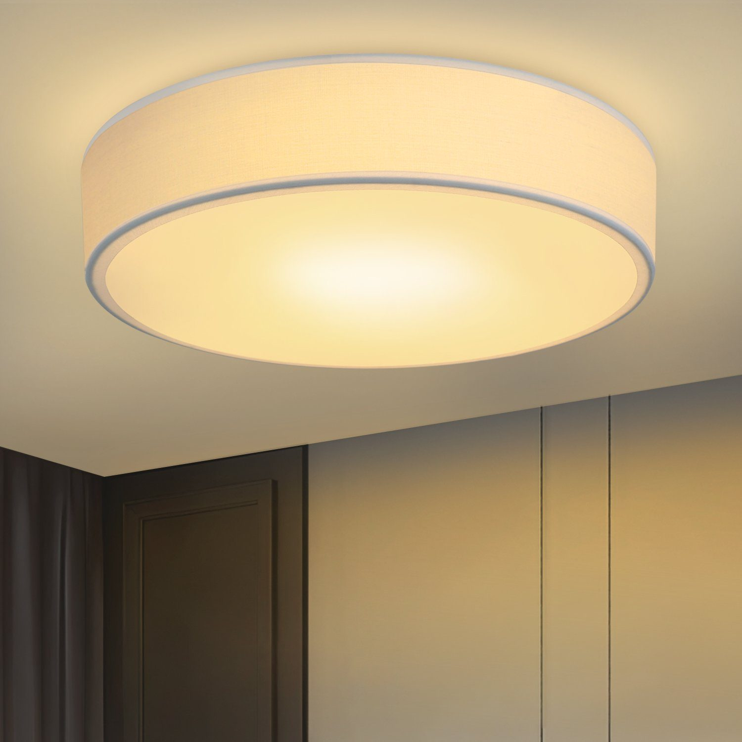 Okrągła lampa sufitowa z białym kloszem, zamontowana na jasnobeżowym suficie.