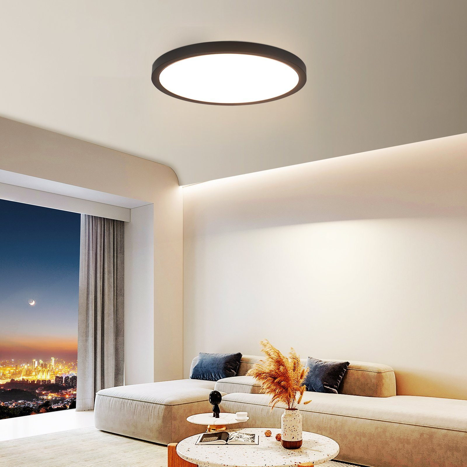 Nowoczesny salon z dużą, okrągłą lampą sufitową. Widoczna sofa, stół i widok nocny przez okno.
