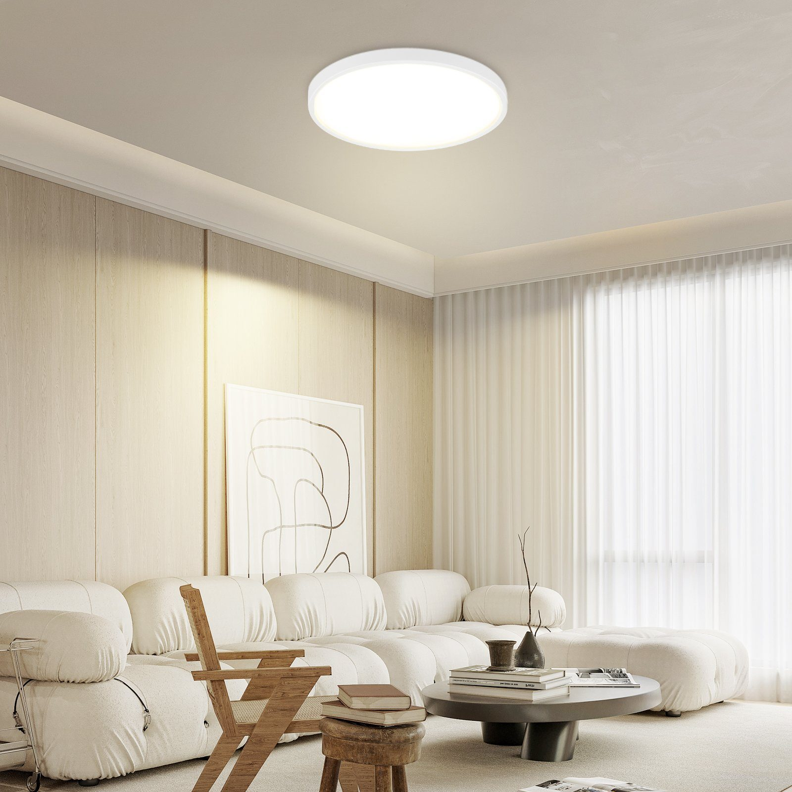 Nowoczesny salon, z białą sofą, jasnymi ścianami i okrągłym stolikiem kawowym.