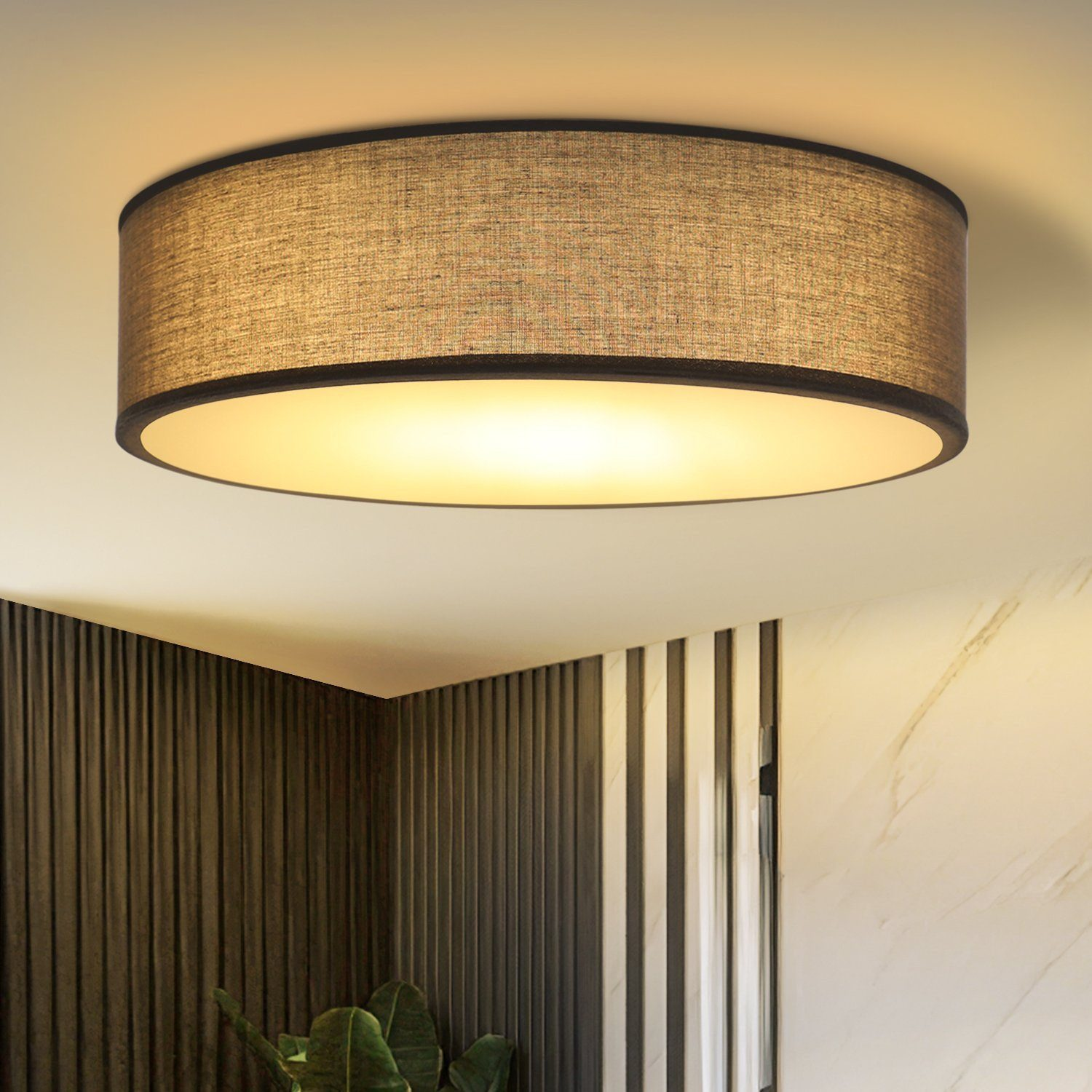 Okrągła lampa sufitowa z materiałowym kloszem. Lampa znajduje się na tle białego sufitu.