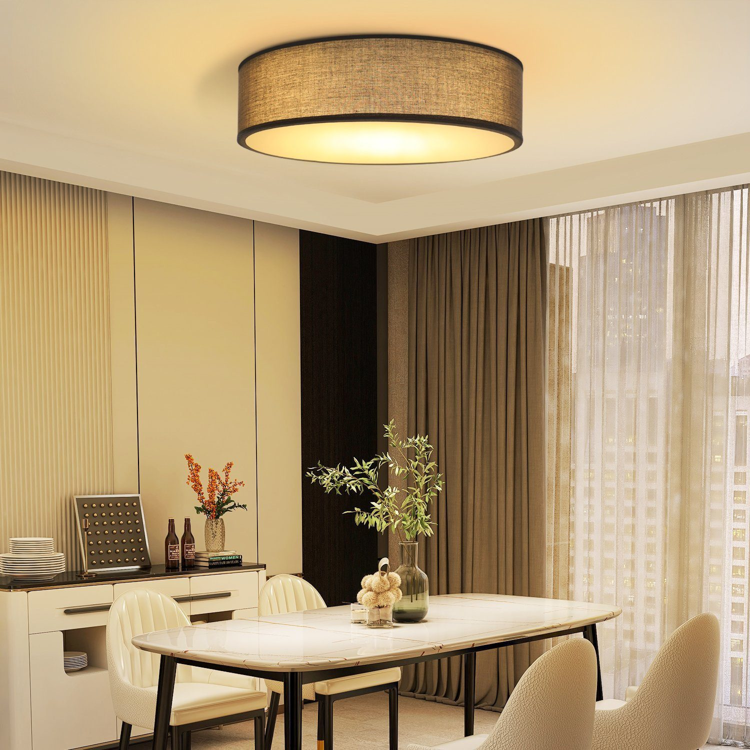 Okrągła lampa sufitowa znajduje się nad stołem jadalnym. Kwiaty są na środku.