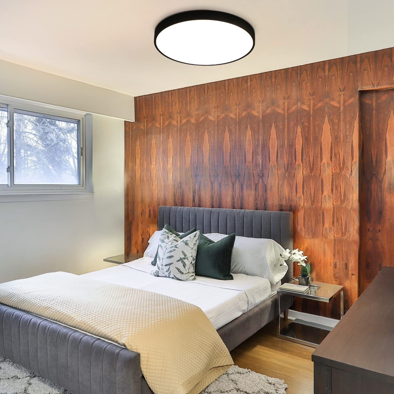 Sypialnia z łóżkiem, szafkami nocnymi i ścianą. Ściana jest wyłożona drewnem, a sufit ma światło.