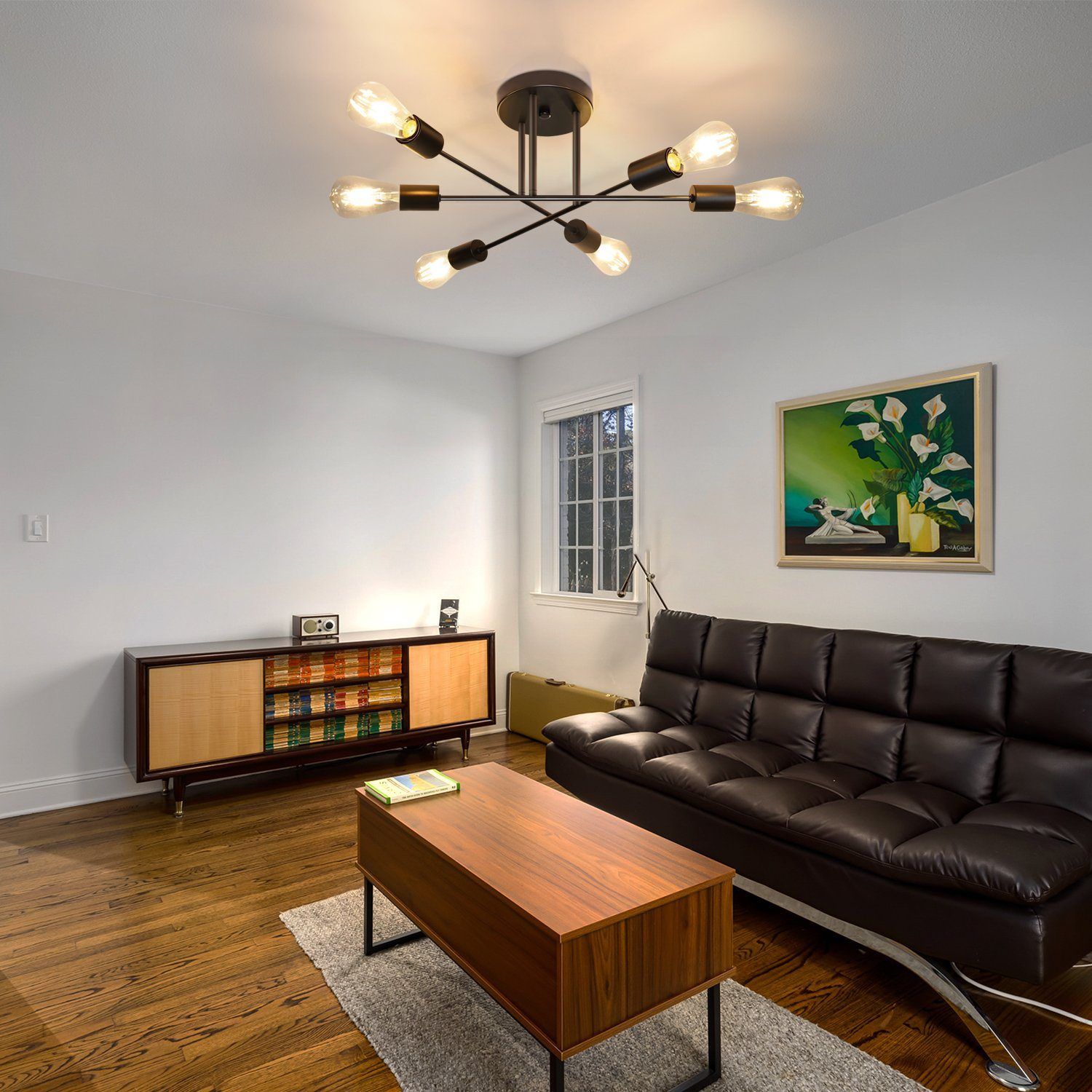 Salon z ciemnobrązową sofą, drewnianym stolikiem kawowym i lampą sufitową.