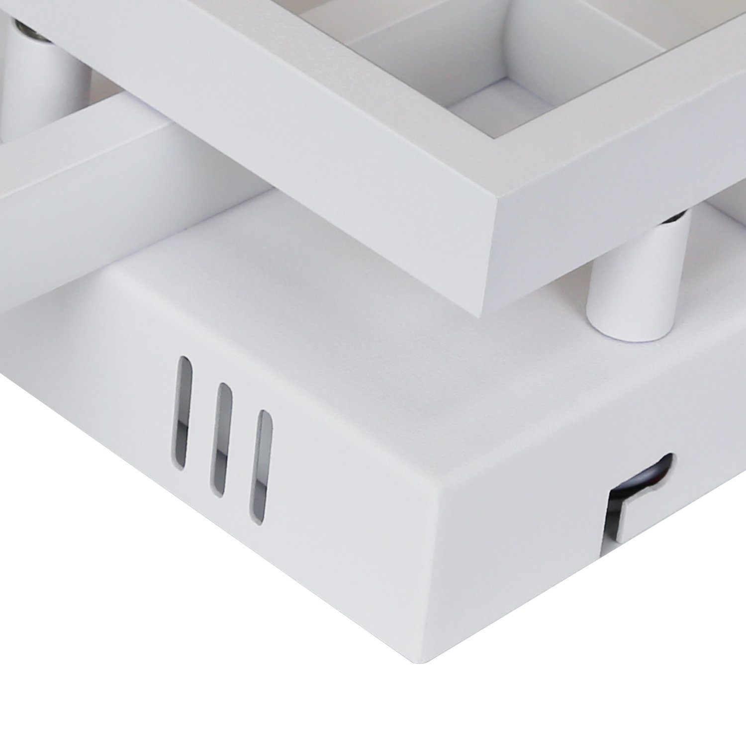 Biała, geometryczna oprawa oświetleniowa sufitowa. Ma kwadratową podstawę i wiele opraw oświetleniowych.