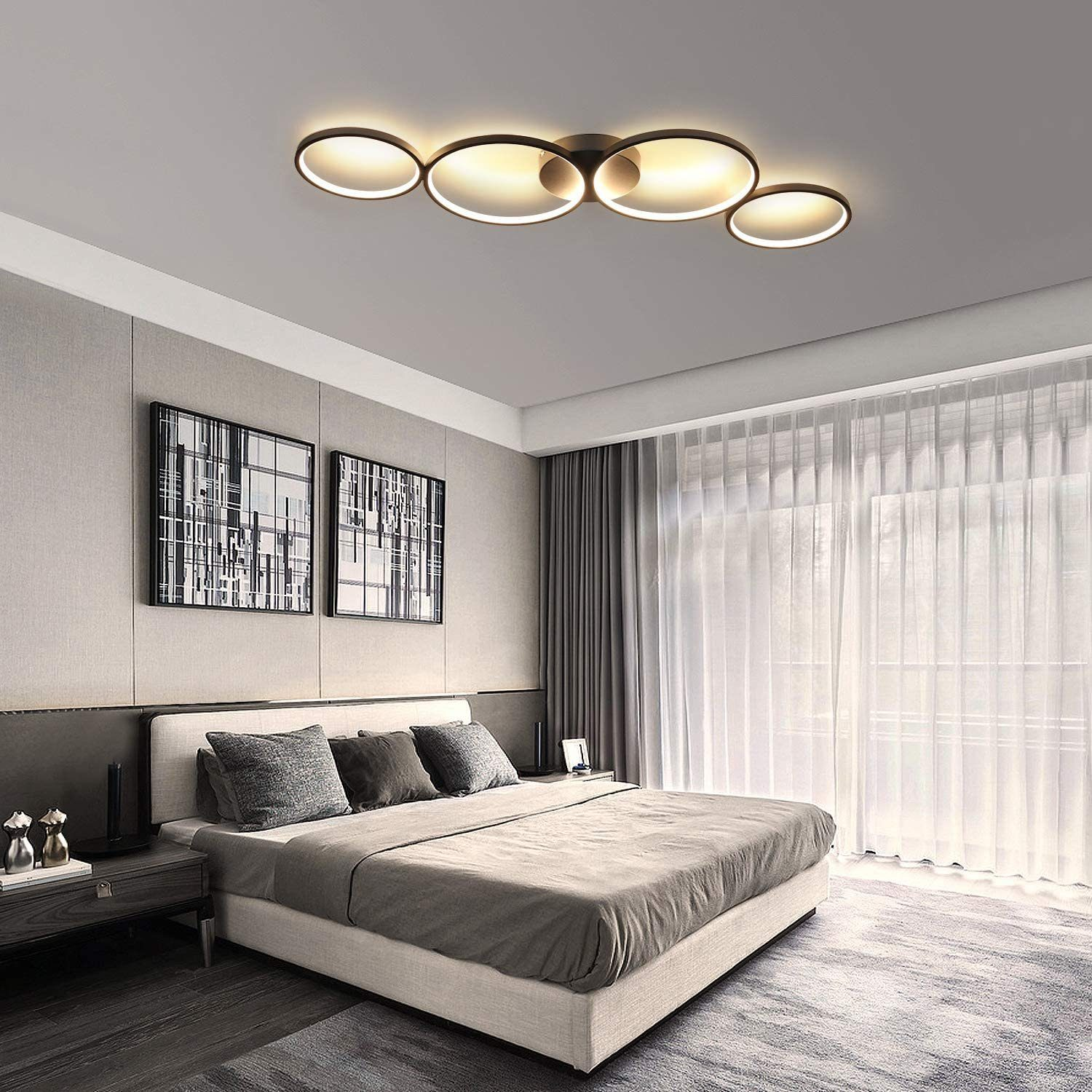 Sypialnia z nowoczesną lampą sufitową, łóżkiem i dziełami sztuki.