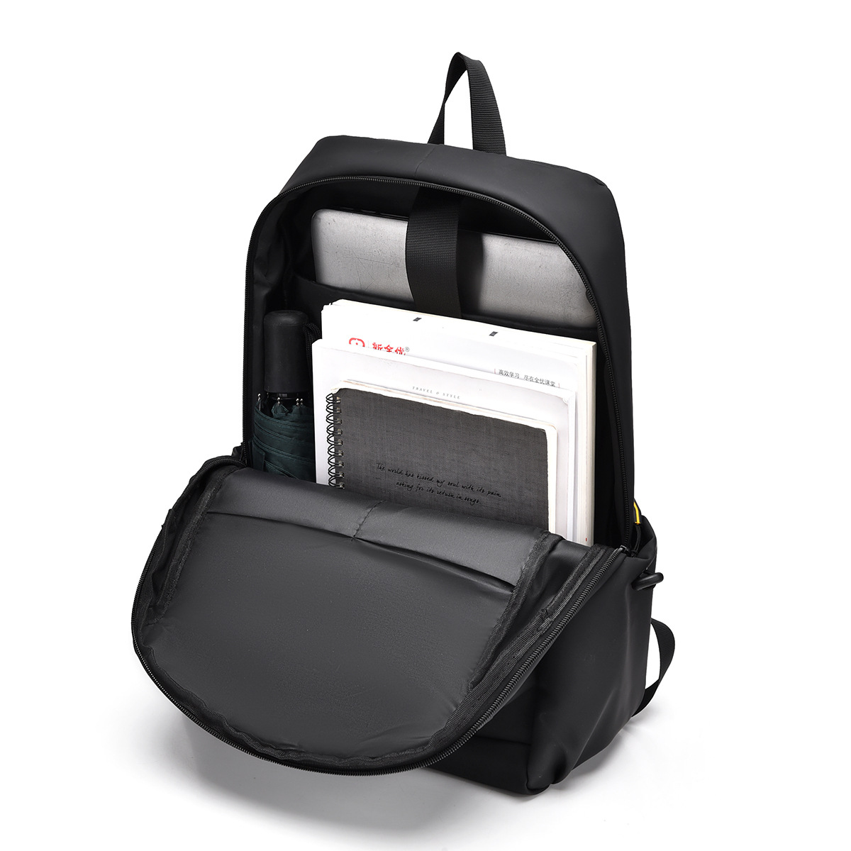 Offener schwarzer Rucksack mit Laptop, Papieren, Regenschirm und Stift darin.
