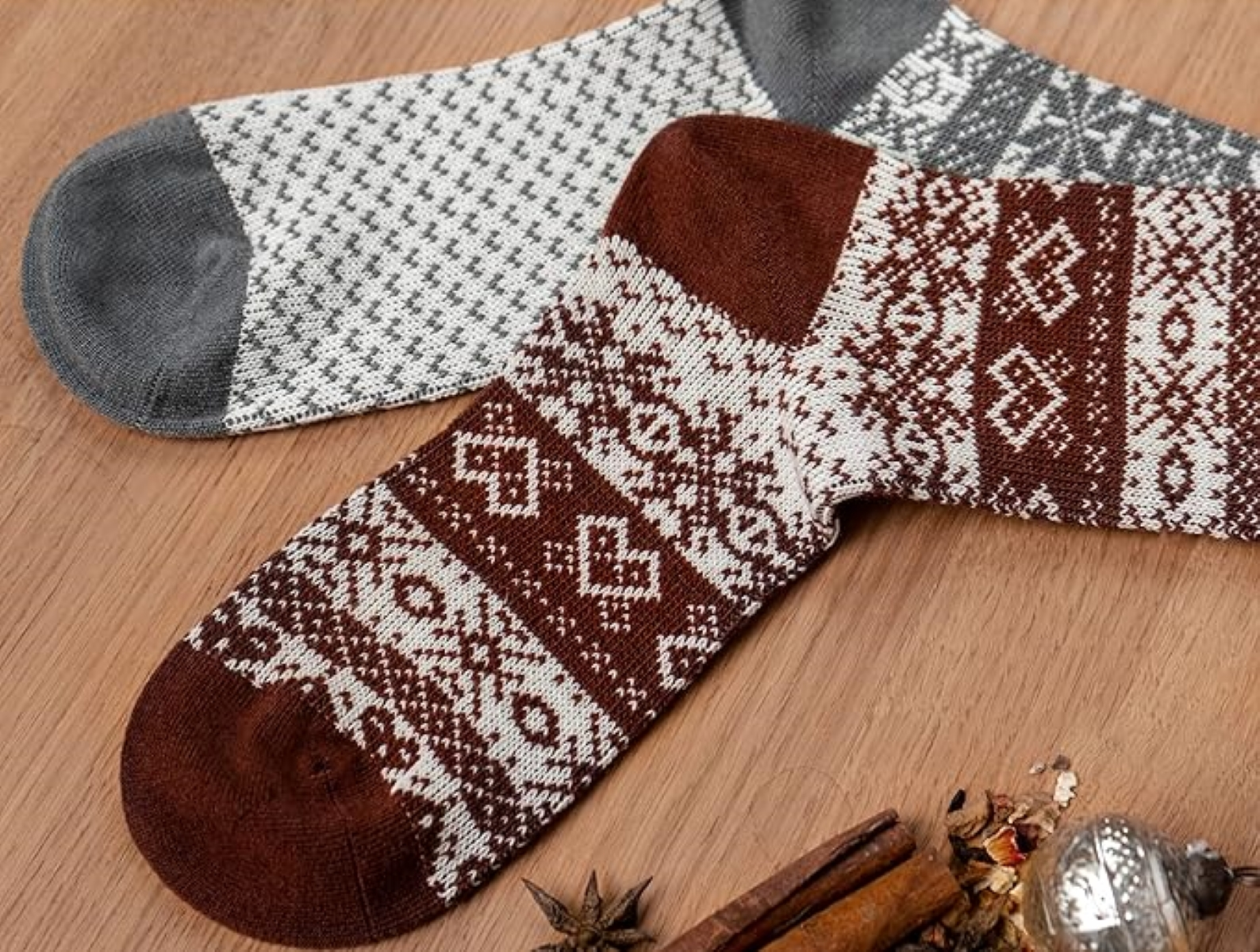 Zwei Paar gemusterte Socken, eines braun-weiß, das andere grau-weiß.