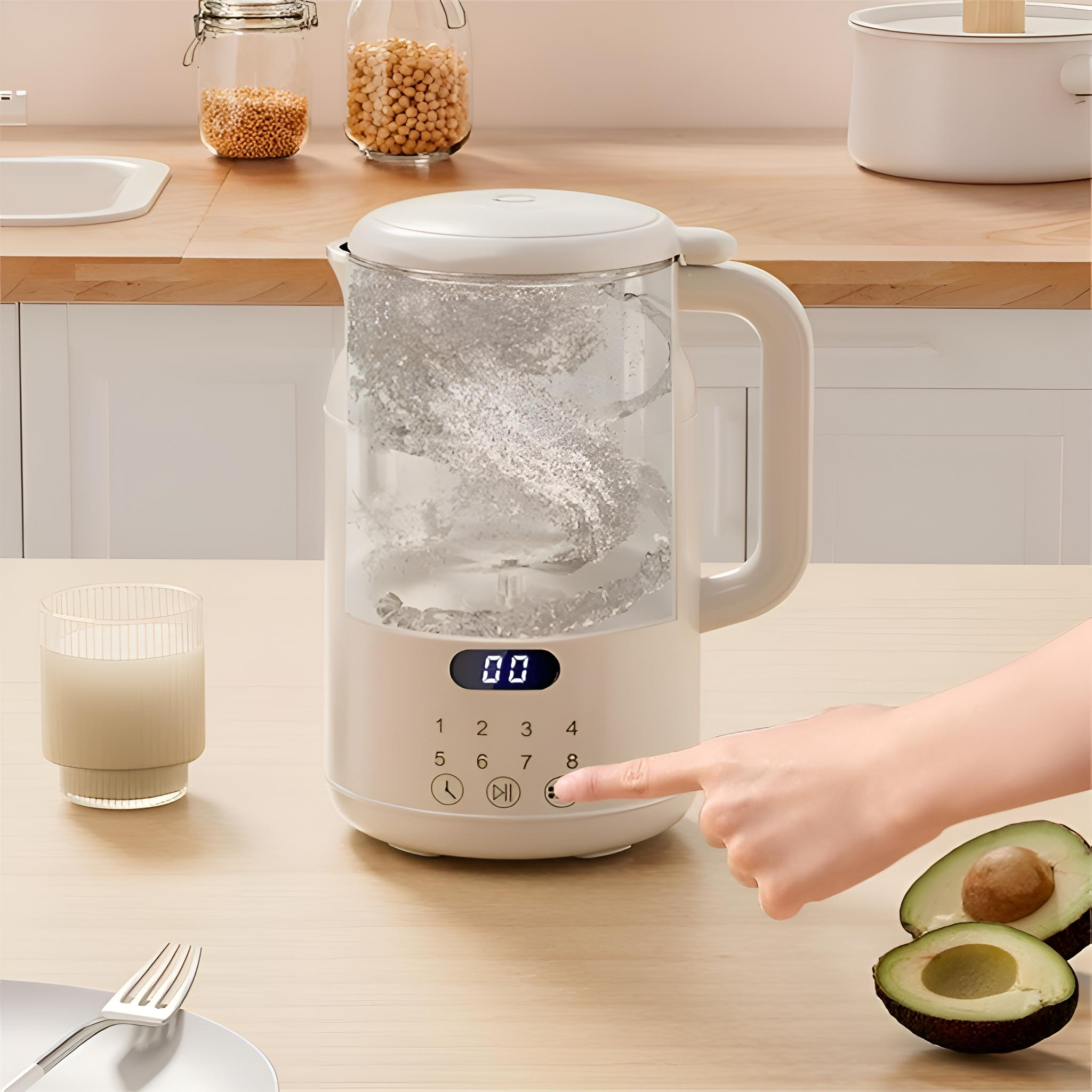 Weißer Wasserkocher mit klarem Glas, Zahlen und einer Hand, die einen Knopf drückt. Avocadohälften.