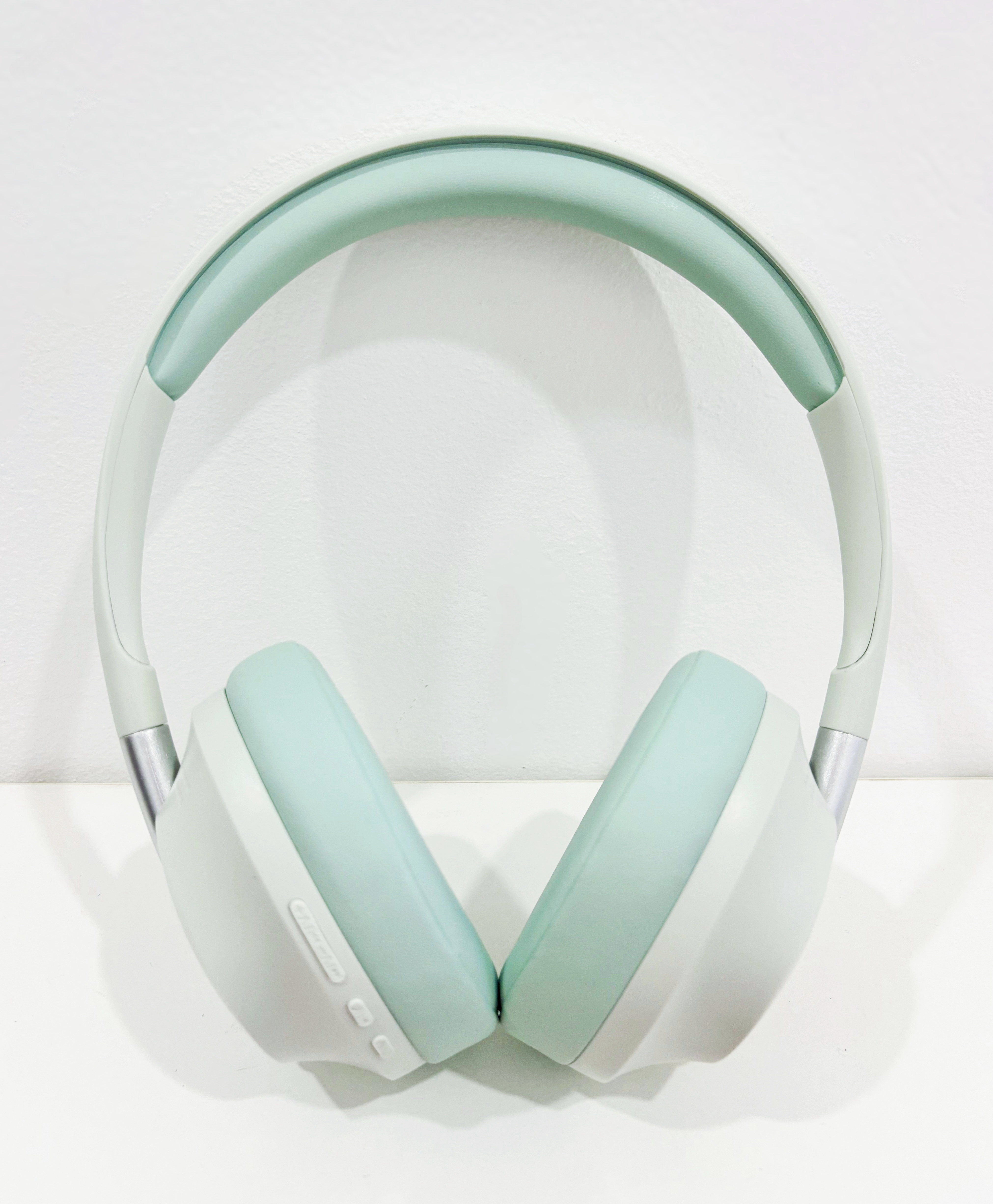 Auriculares, esquema de color verde claro y blanco, estudio, fondo blanco.