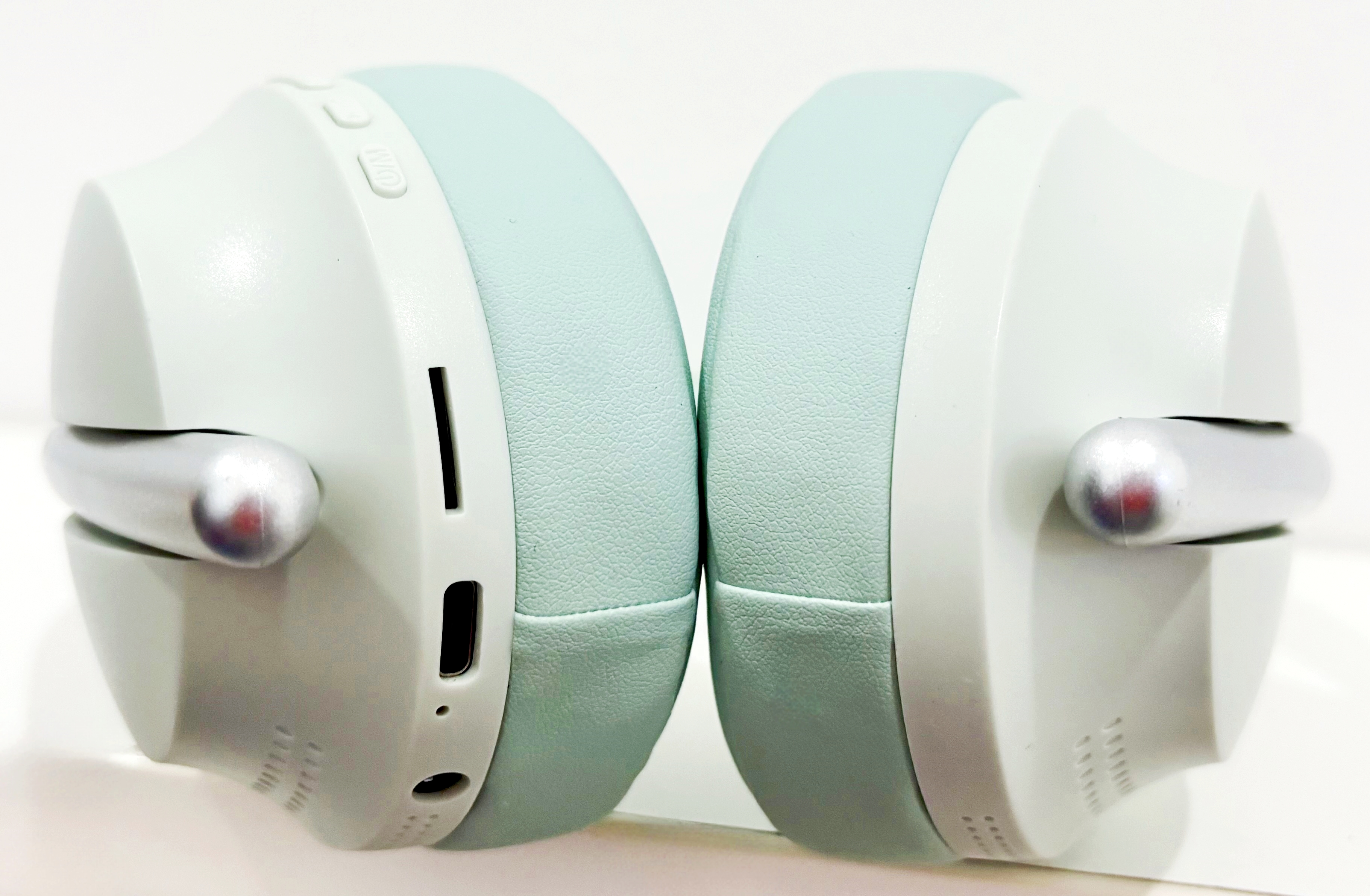 Auriculares verde menta. Tienen detalles plateados y están plegados.