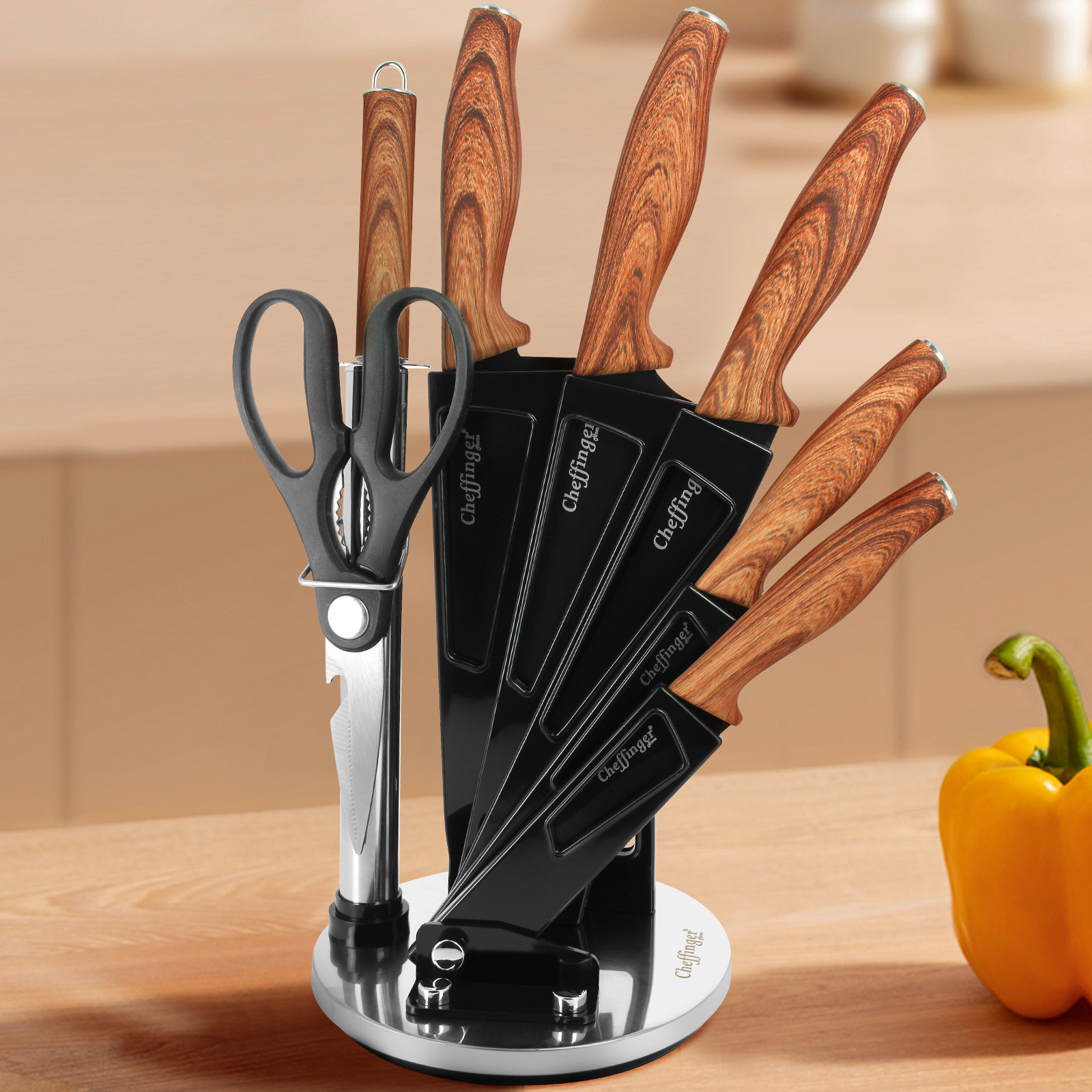 Messerset mit Holzgriffen, Schere und gelber Paprika auf einem Tisch.