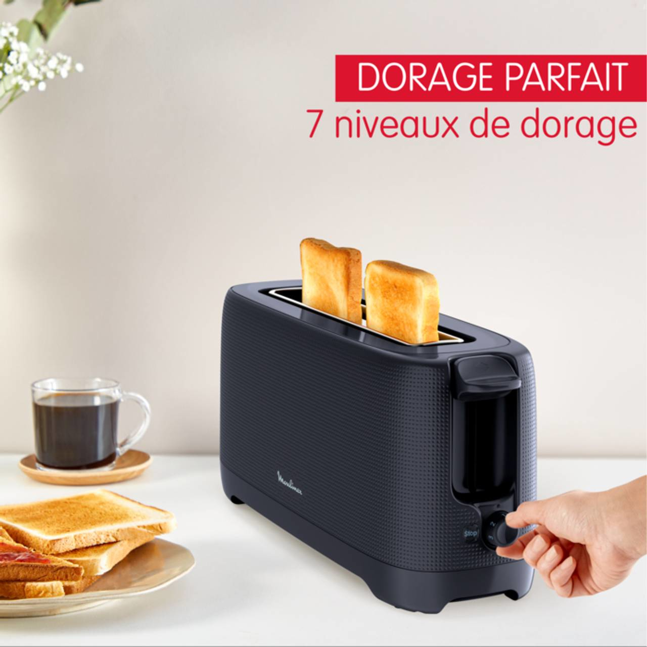 Zwarte broodrooster met twee sneetjes toast. Hand draait aan de knop, en de tekst luidt '7 bruiningsniveaus'.