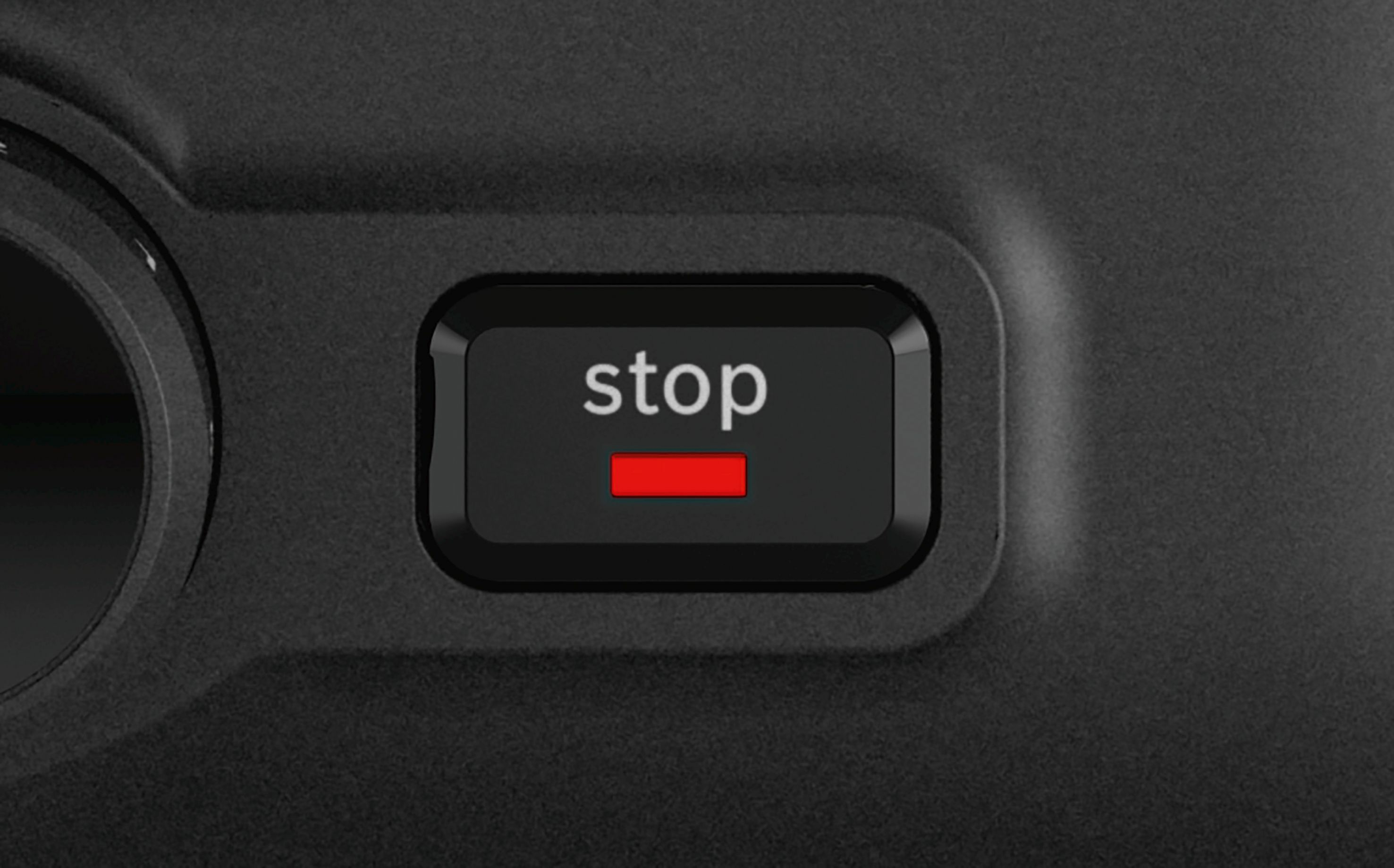 Zwarte bedieningsknop met het woord "stop" erop en een rode lijn eronder.