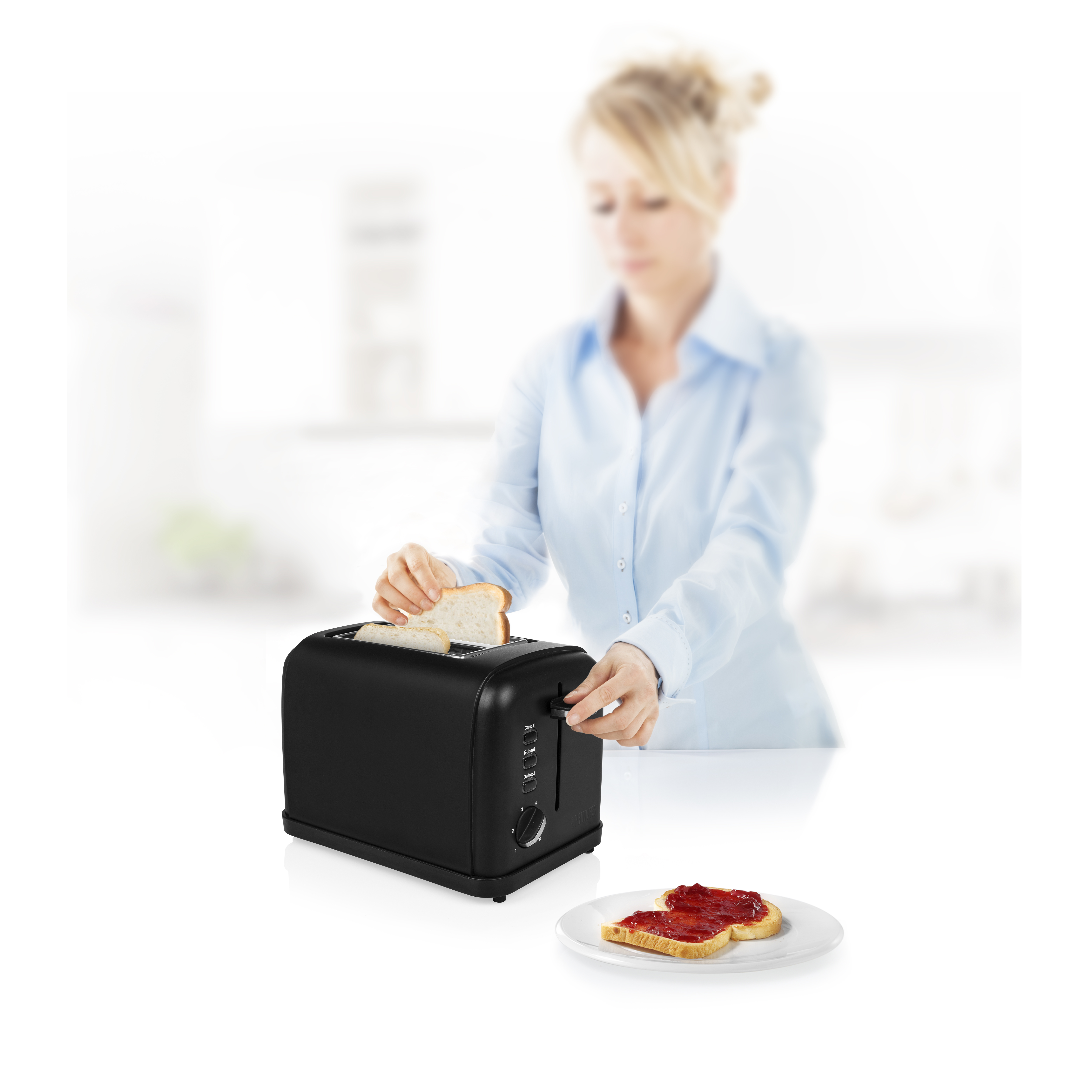 Mujer poniendo pan en una tostadora negra. Dos rebanadas de tostadas con mermelada en un plato.