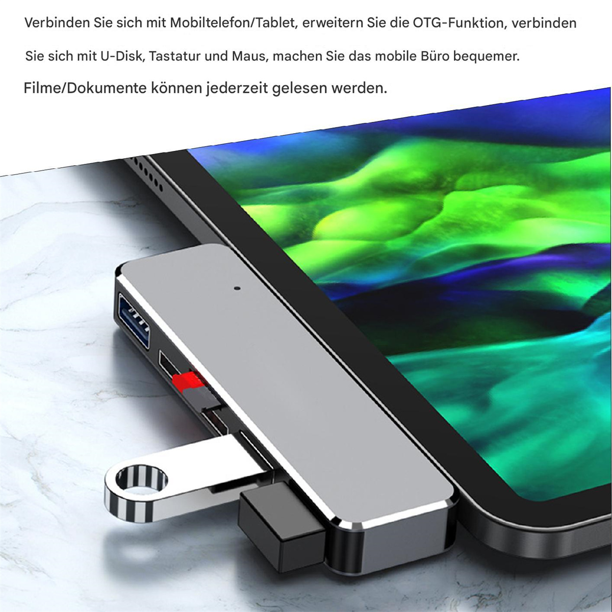 Ein silberner Adapter ist mit einem Tablet verbunden. Es hat einen USB-Anschluss und einen Befestigungspunkt. Text auf Deutsch.