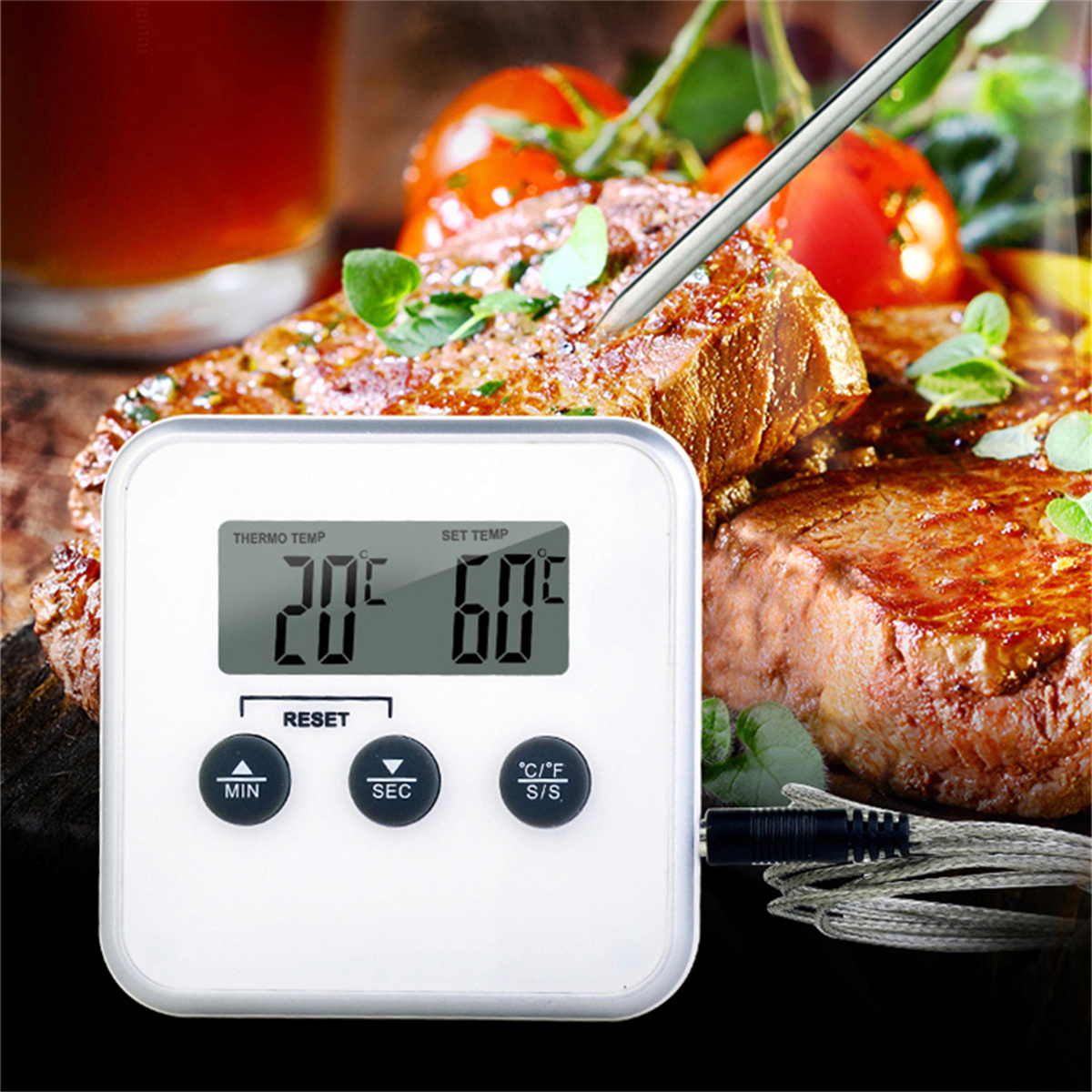 Weißes Thermometer zeigt 20°C und 60°C an. Fleisch und Tomaten im Hintergrund.