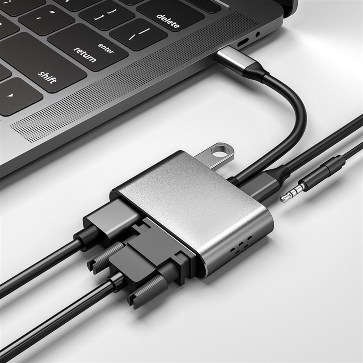 Laptop mit USB-C-Hub, der mit mehreren Kabeln verbunden ist. Ein Kabel ist mit dem Laptop verbunden.