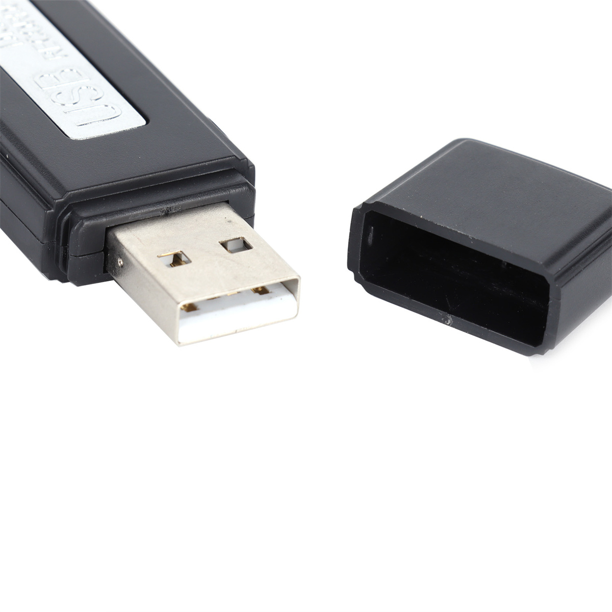 Ein schwarzer USB-Stick mit einem silbernen USB-Anschluss. Die Kappe ist abgenommen und liegt daneben.