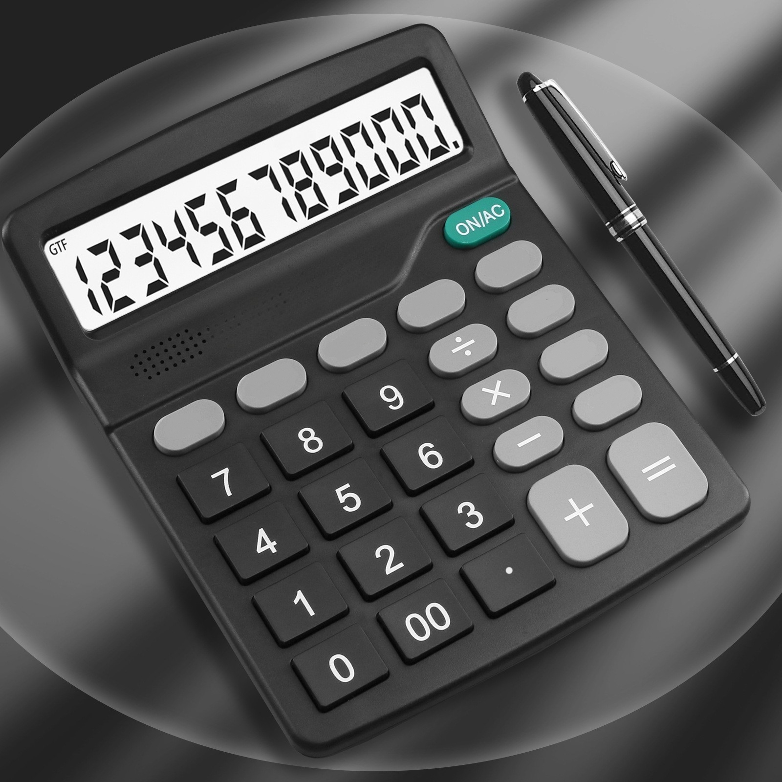 Schwarzer Taschenrechner mit grauen Tasten, Anzeige: '123456789000'. Ein schwarzer Stift liegt rechts.