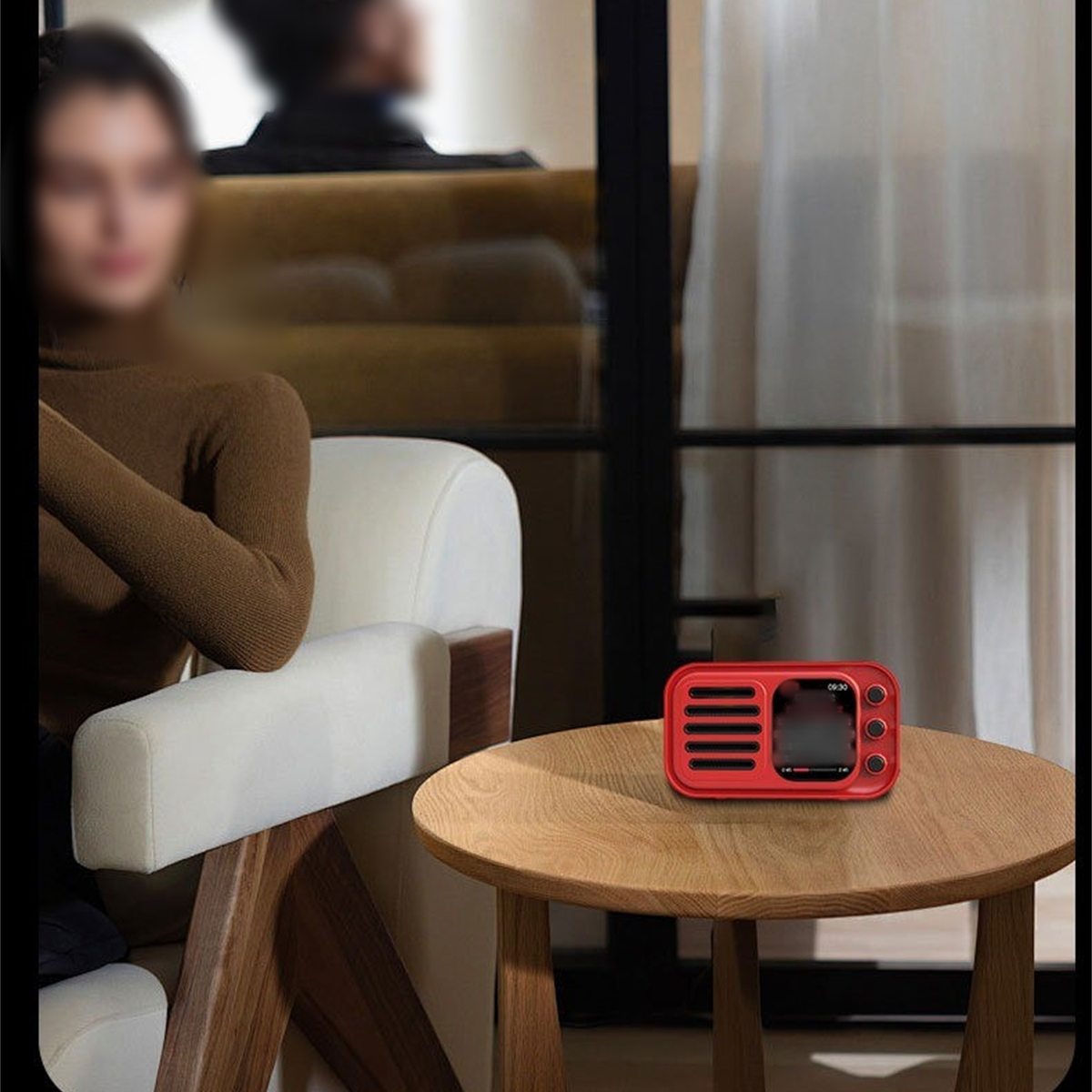 Ein kleines rotes Retro-Radio auf einem Holztisch. Eine Person ist unscharf im Hintergrund.
