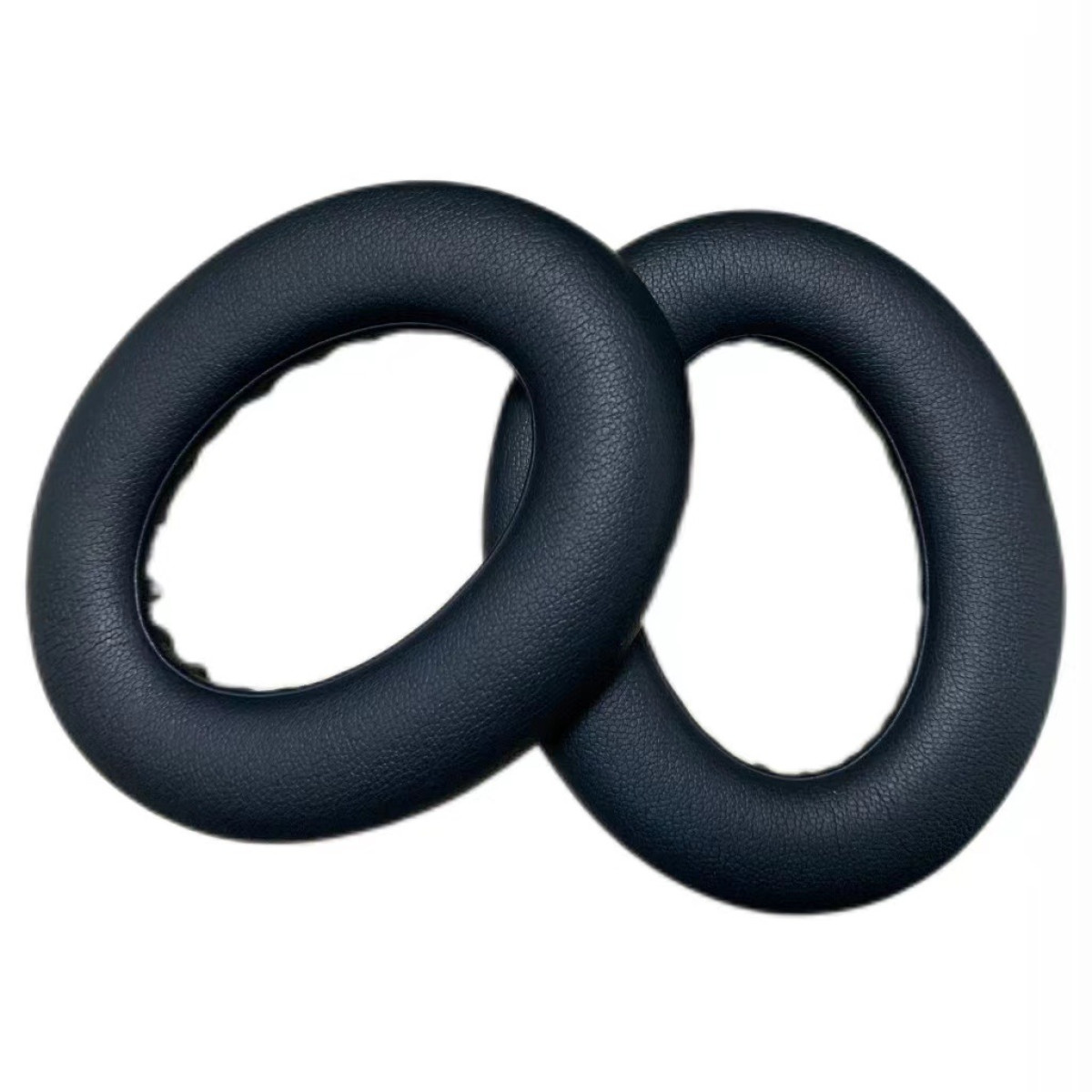 Dwie ciemnoniebieskie, owalne poduszki na uszy na białym tle.