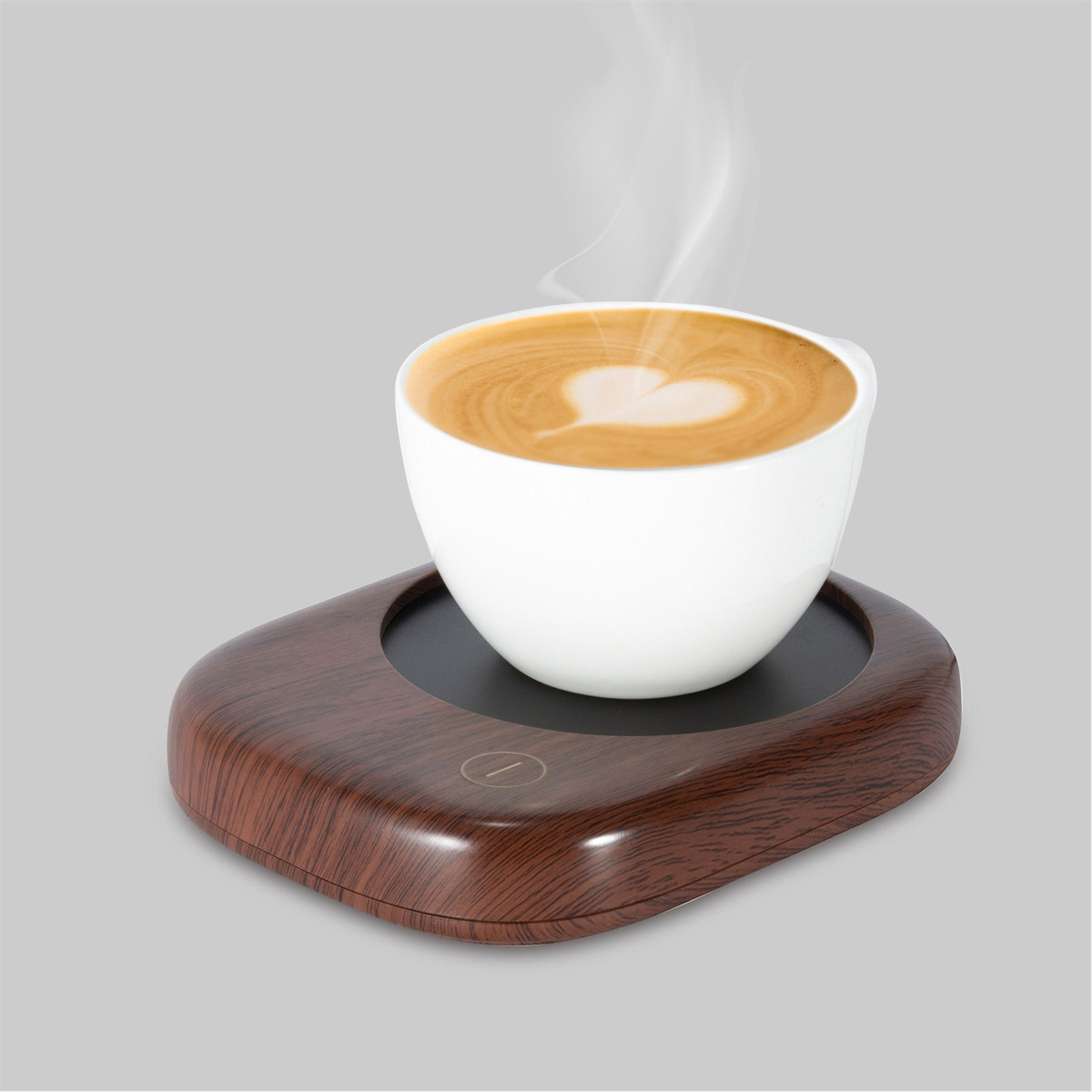 Eine weiße Kaffeetasse mit herzförmigem Schaumdesign auf einem Holz-Warmhalter, dampfend.