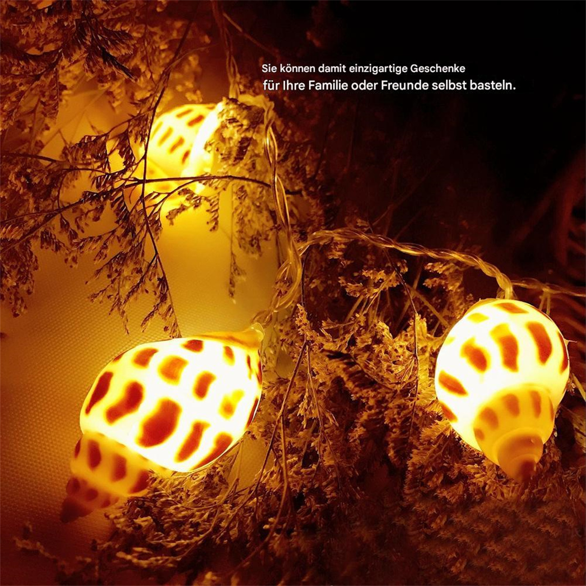 Lichterkette mit muschelförmigen Lichtern auf braunen Ästen, mit Text.