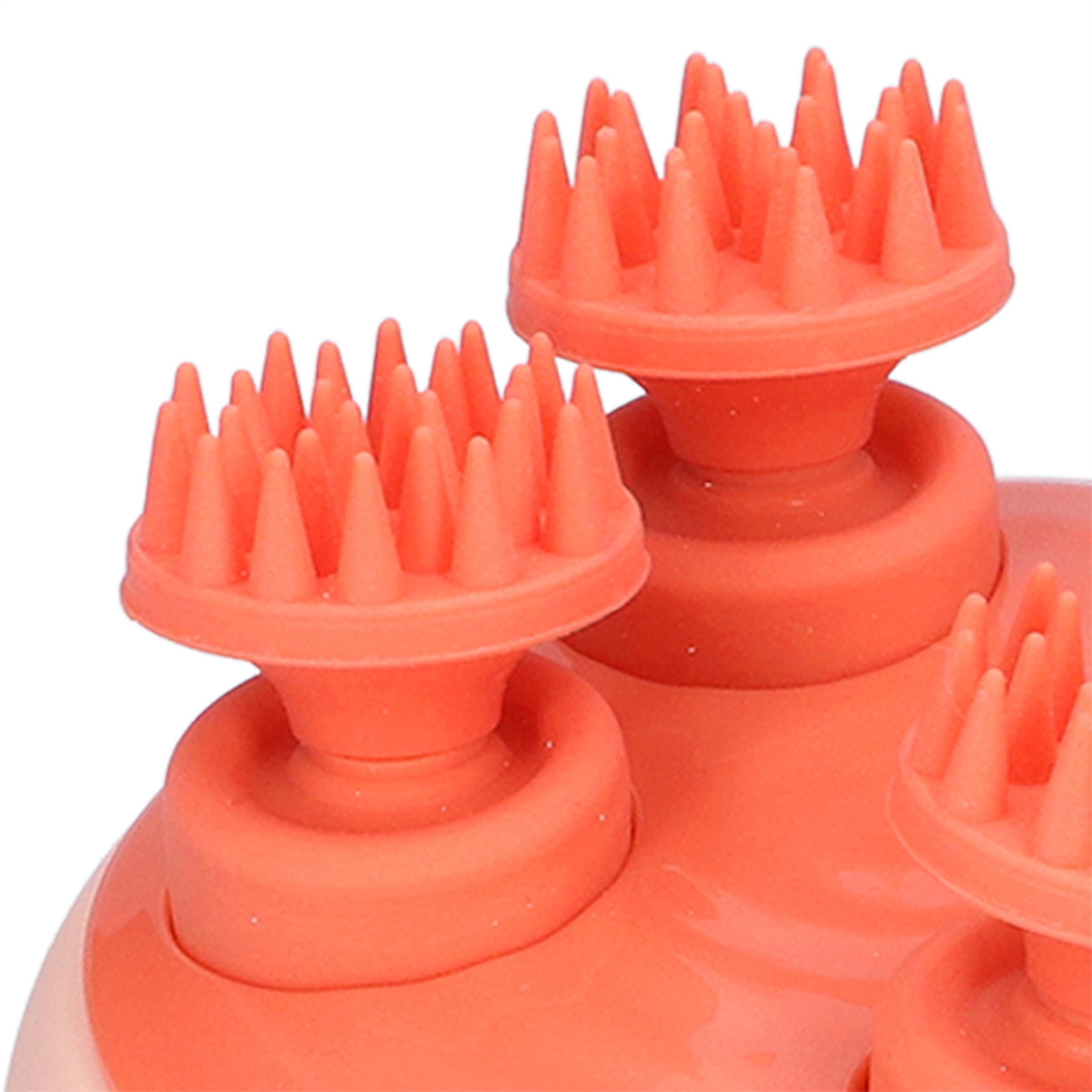 Nahaufnahme eines orangenen Kopfhautmassagers mit mehreren Gumminoppen.