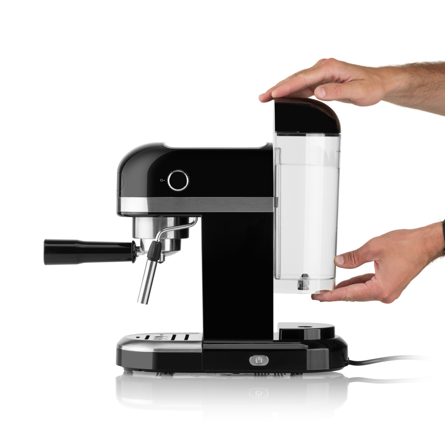 Macchina per espresso nera con serbatoio dell'acqua riempito da mani, sfondo bianco.