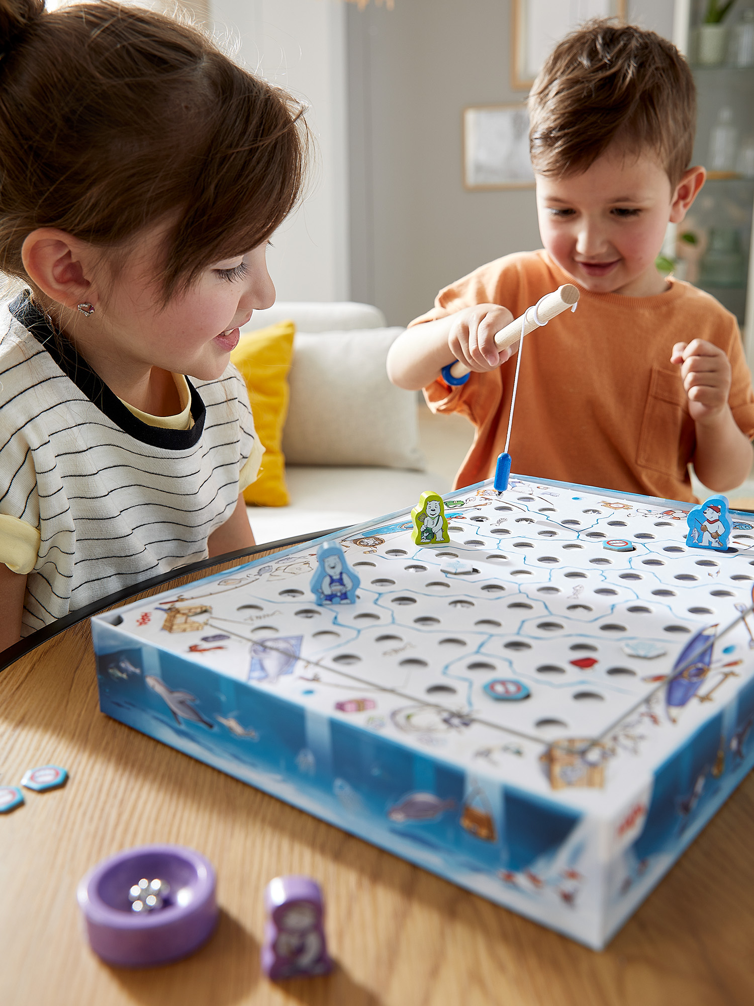 Zwei Kinder spielen ein Angelspiel. Sie konzentrieren sich auf das Spielbrett.