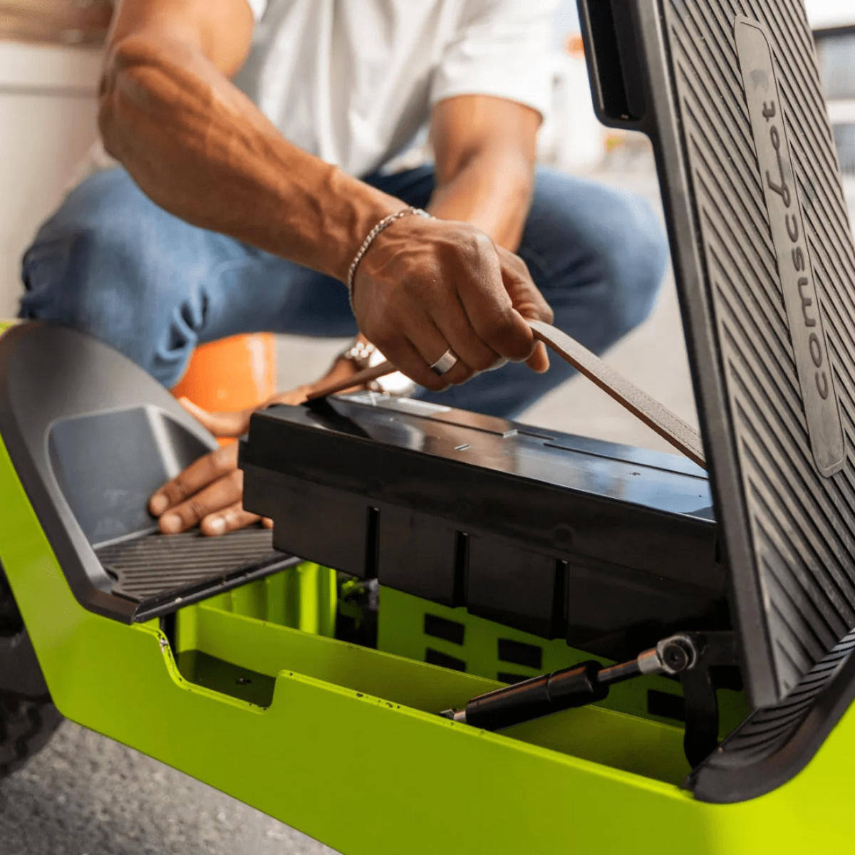 Person arbeitet an einem Roller. Sie entnehmen einen Akku aus dem Roller.