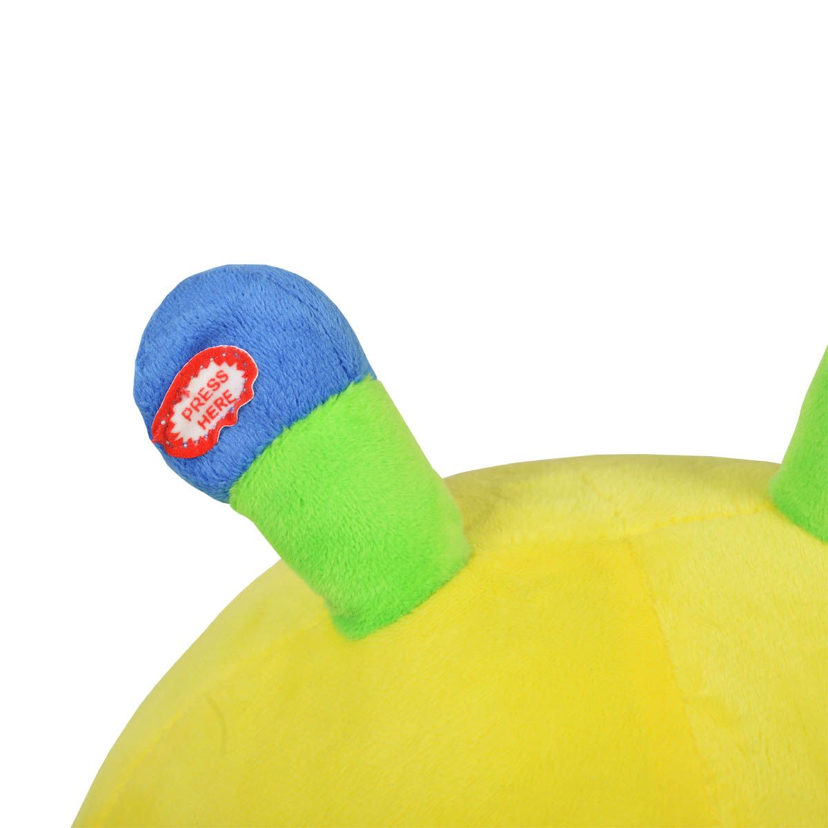 Una oreja de un peluche amarillo con punta azul. La oreja dice "PRESIONA AQUÍ" en una etiqueta roja.