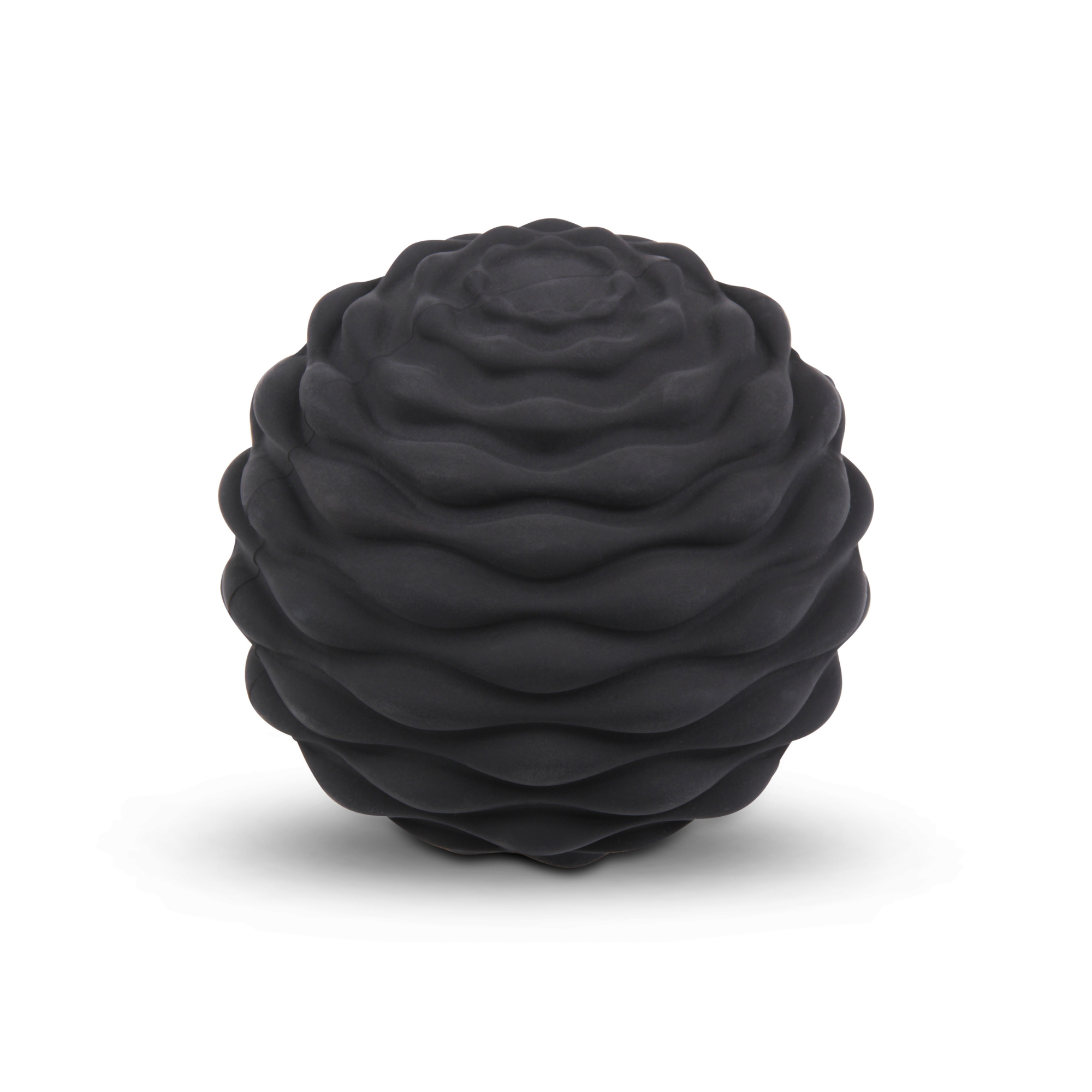 Une balle de massage en mousse noire avec un motif texturé en forme de vague.