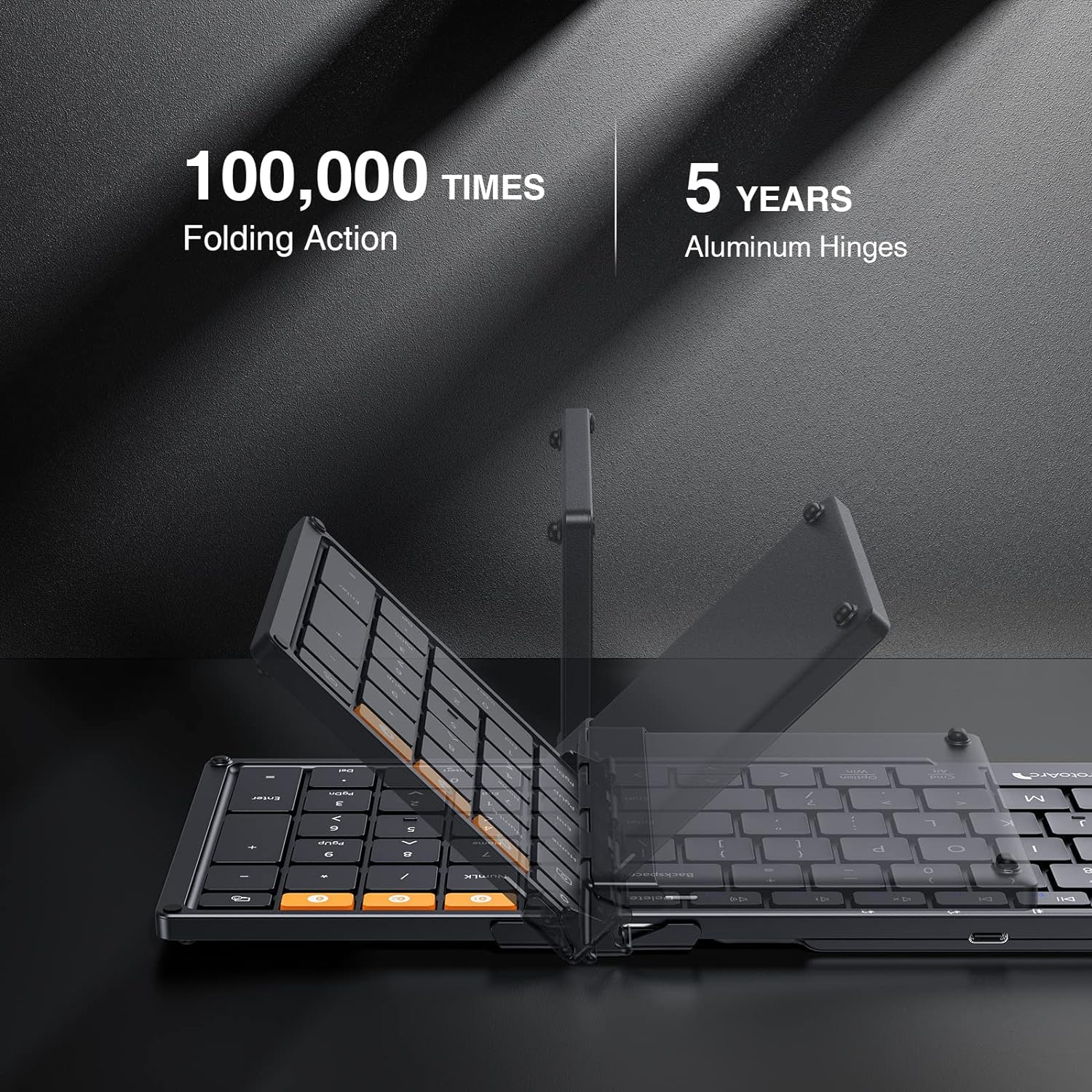 Schwarze, zusammenklappbare Tastatur mit orangefarbenen Tasten, auf dunkler Oberfläche.