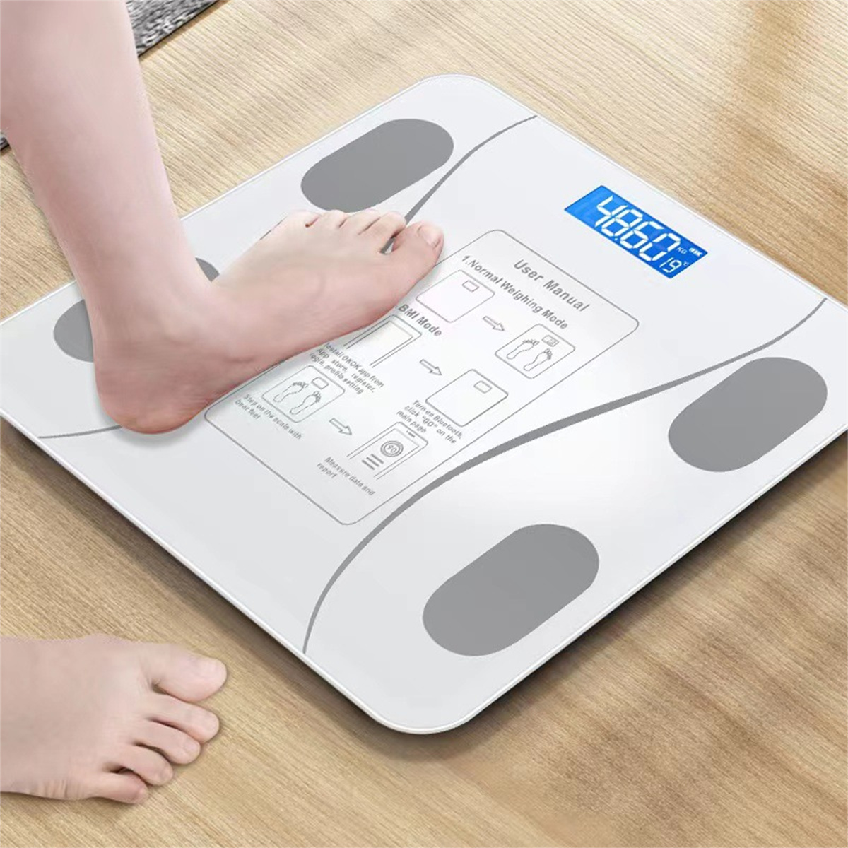 Ein Fuß auf einer weißen Digitalwaage, die 48,60 kg anzeigt. Ein weiterer Fuß ist auf dem Boden sichtbar.