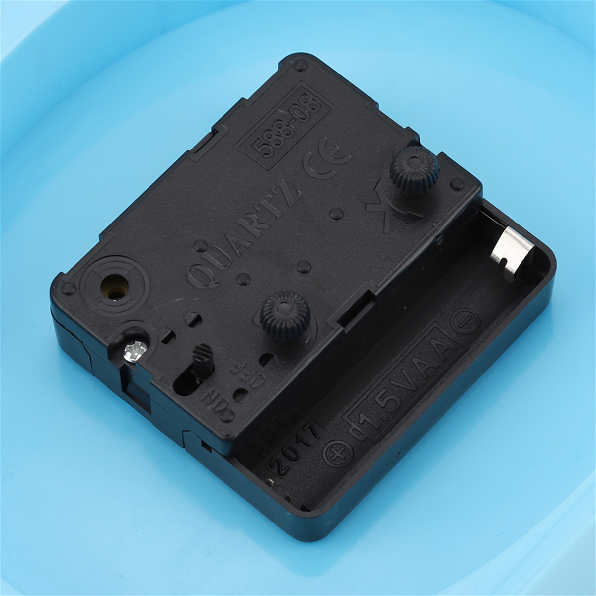 Das Innere einer Uhrkomponente mit Batteriefach und Zahnrädern.