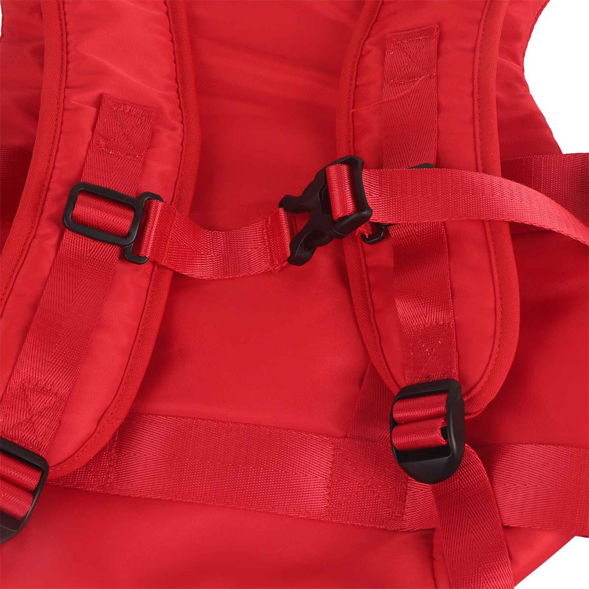 Rote Rucksackgurte mit schwarzen Schnallen. Die Gurte sind mit einem schwarzen Kunststoffclip verbunden.