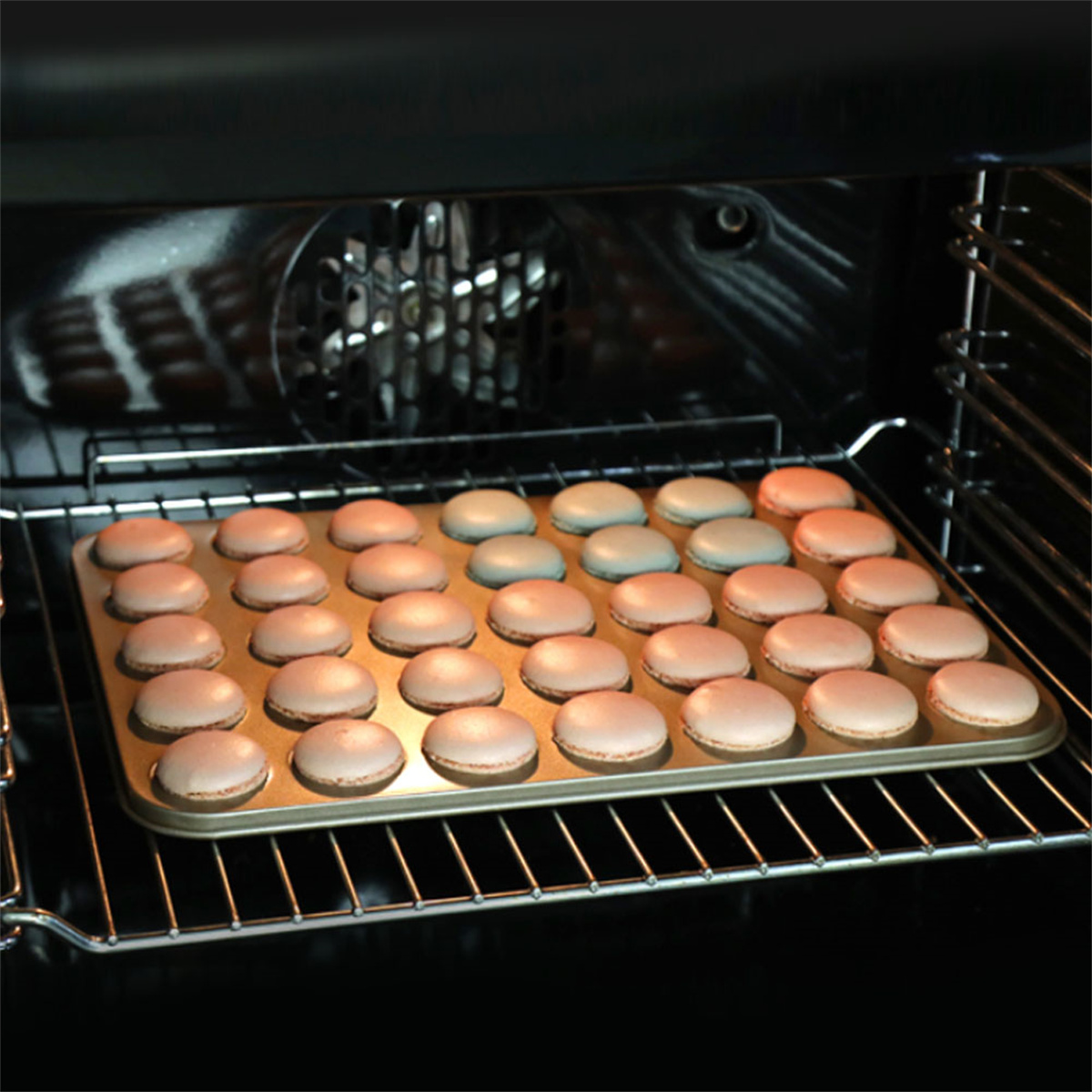 Macarons im Backblech, im Ofen. Beige und rosa Macarons.